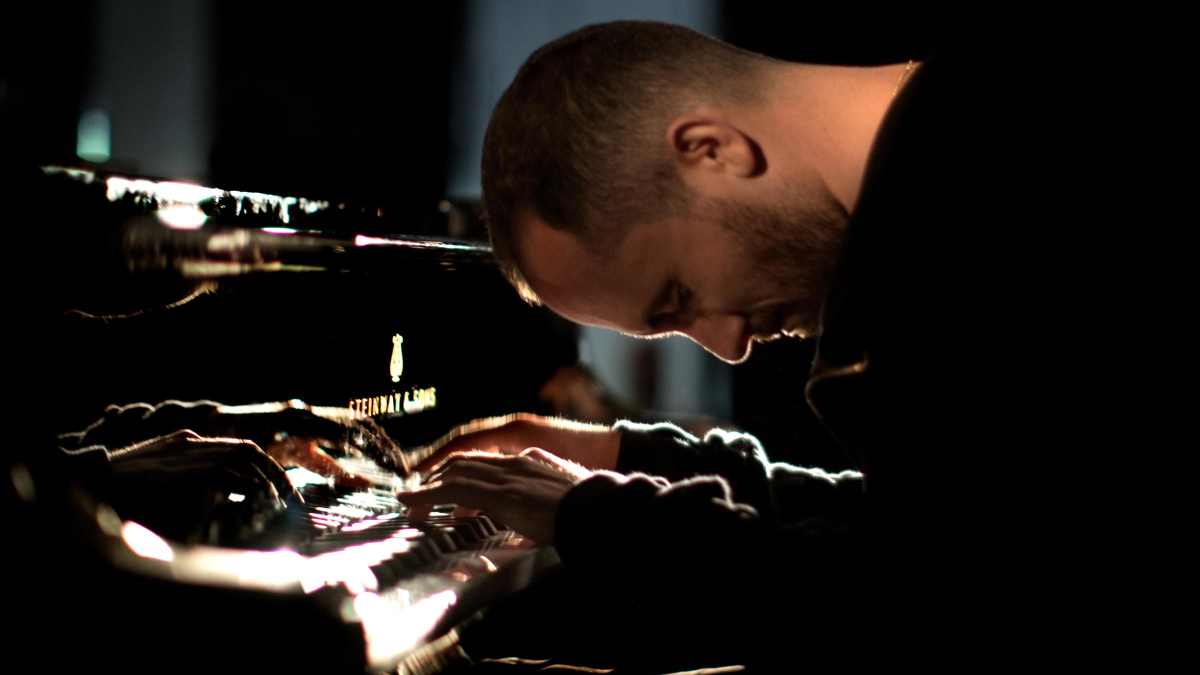 "Silvesterkonzert aus der Semperoper 2021 - Von Berlin bis Broadway": Der Pianist Igor Levit spielt auf einem schwarzen Flügel. Den Kopf hat er dabei ganz tief nach unten gebeugt - versunken in sein Spiel.