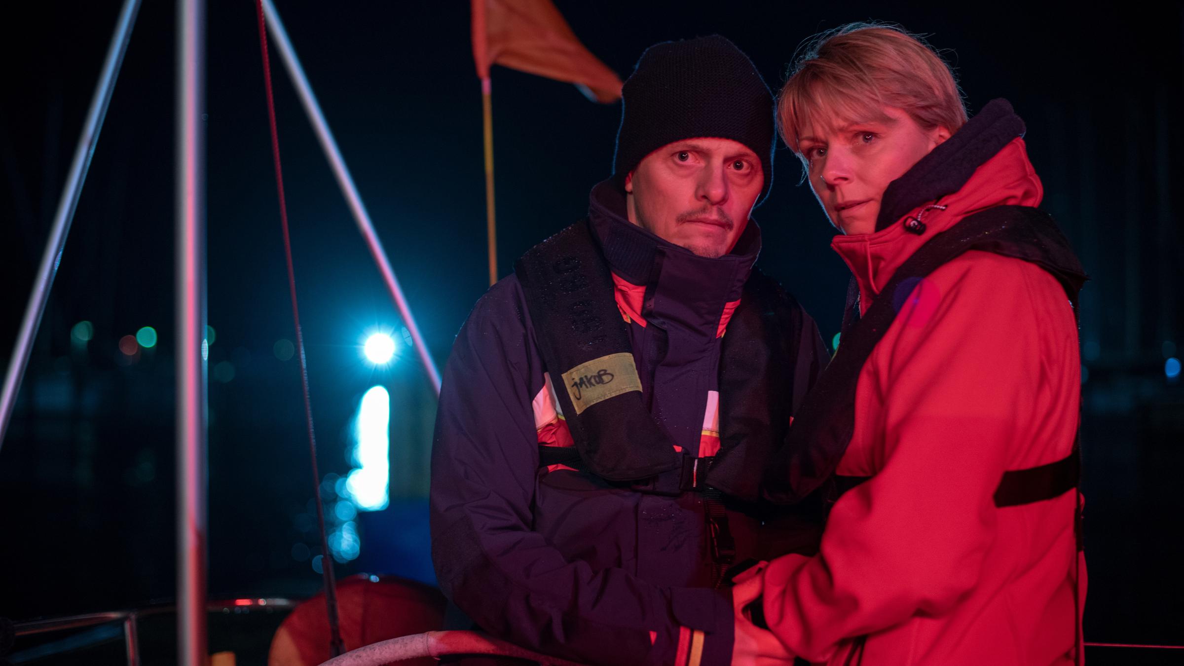"Tod von Freunden - Sabine und Jakob": Jakob (Thure Lindhardt) und Charlie Jensen (Lene Maria Christensen) stehen kurz nach dem Unglück bei Nacht auf dem Segelschiff am Steuer, sie schauen ernst, er hält leicht ihre Hand.