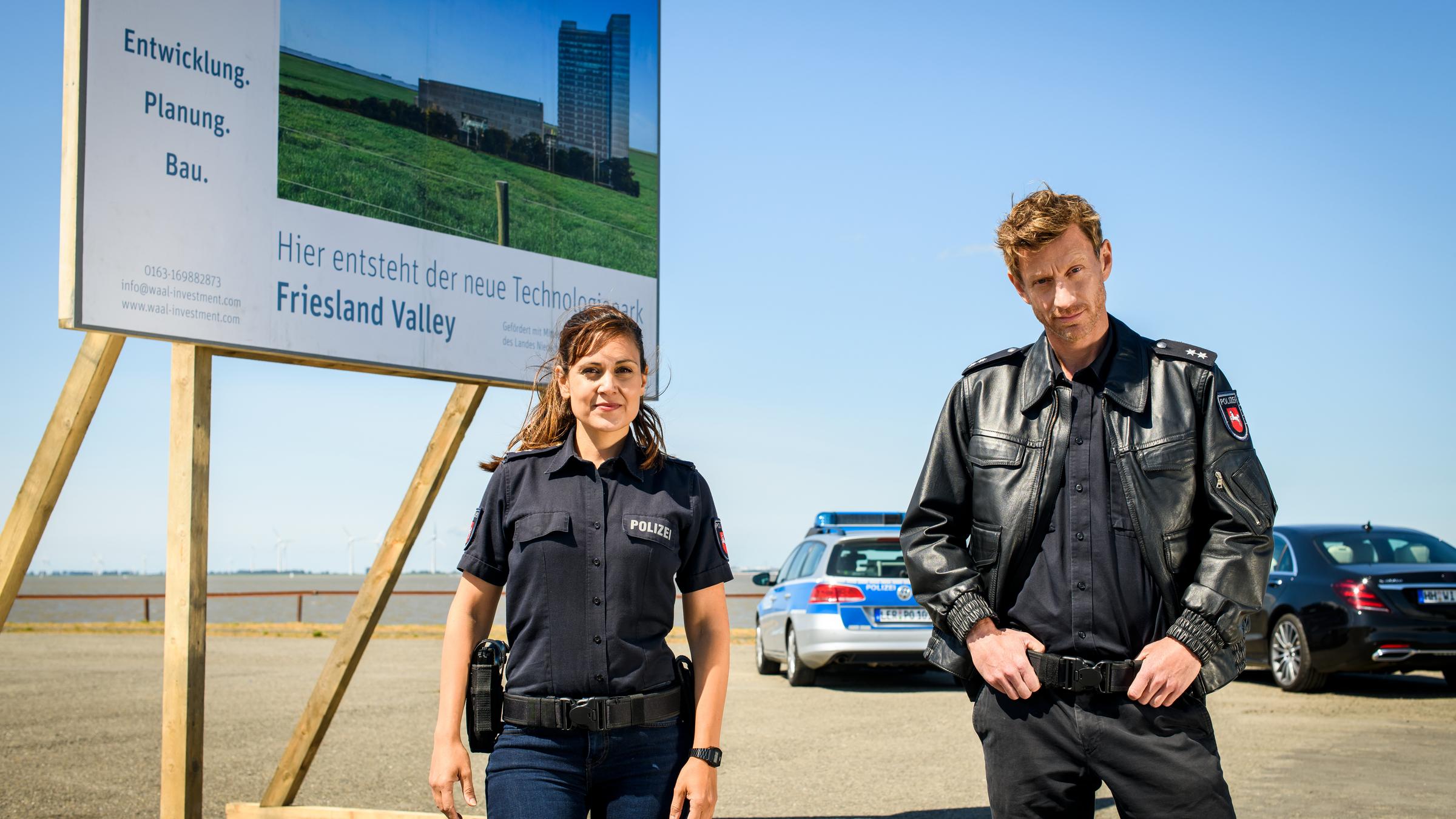 "Friesland - Haifischbecken": Süher Özlügül (Sophie Dal, l.) und Henk Cassens (Maxim Mehmet, r.) stehen vor einer Plakatwand.