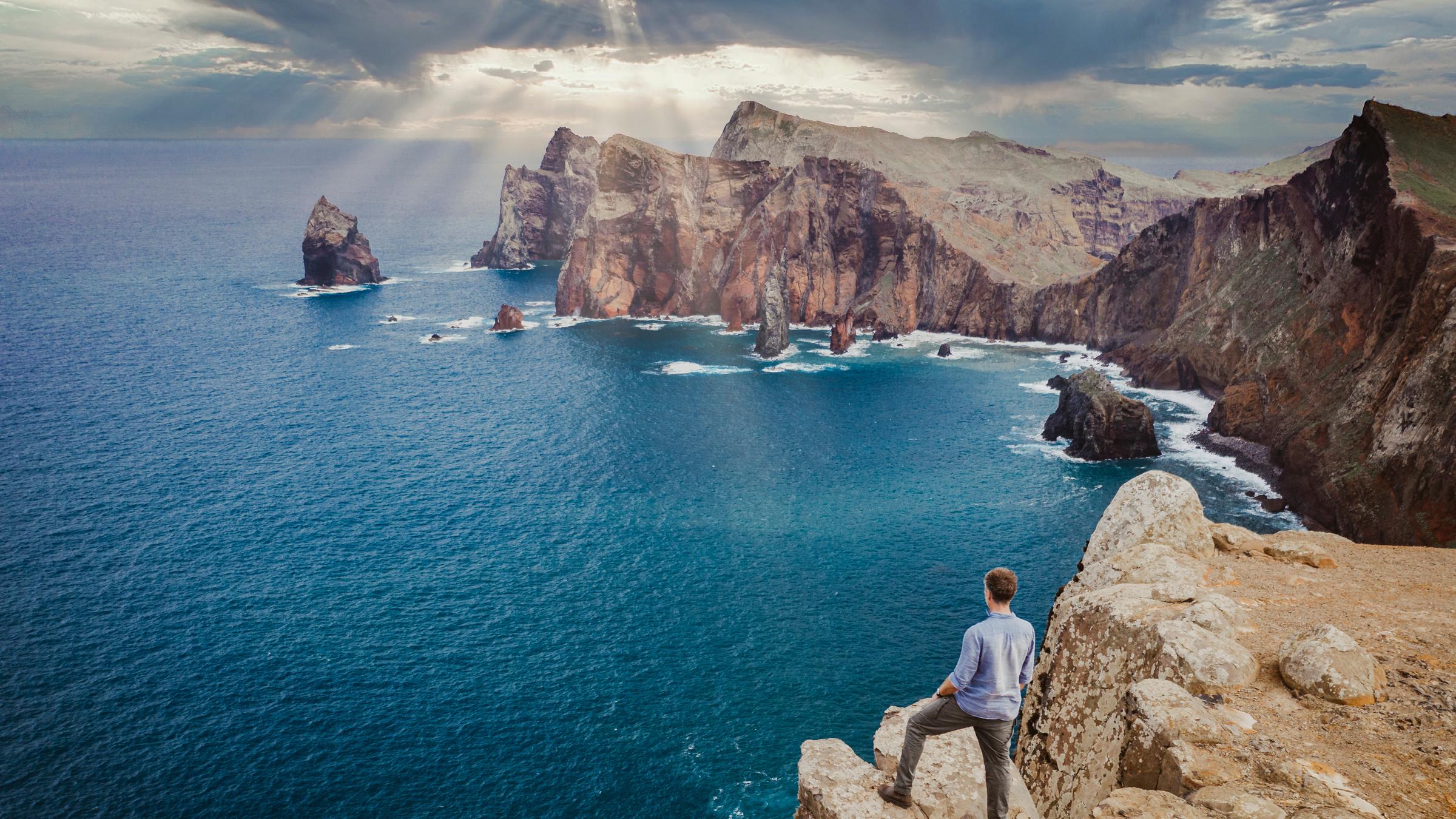 "Terra X - Faszination Erde - Mit Dirk Steffens - Makaronesien: Oasen in der blauen Wüste": Dirk Steffens steht auf einer Klippe mit Blick auf eine Felsenbucht.