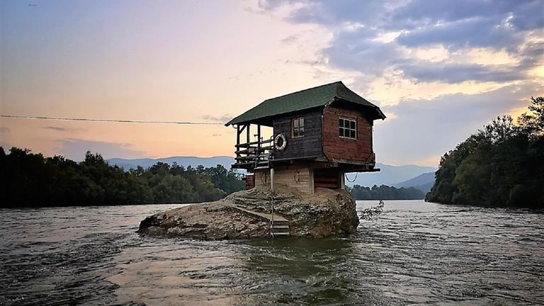 "Balkan-Style (1) - Durch Europas wilden Südosten": Inmitten des Flusses Drina steht ein Holzhaus auf einem Felsen.