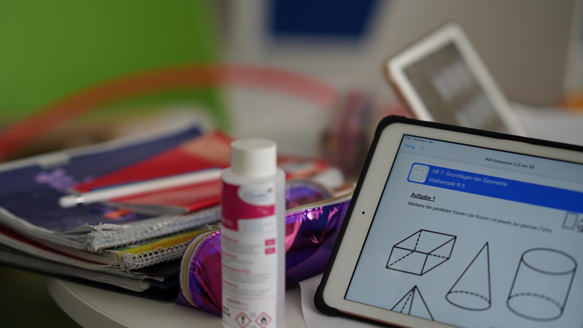 "ZDFzoom: Schulen im Corona-Stress - Lernen aus der Krise": Tisch mit Heften, Tablett und einer Flasche Desinfektionsmittel.