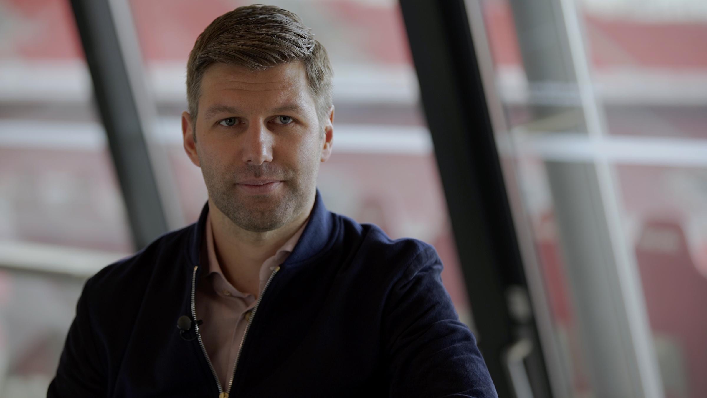 "37°: In der Abseitsfalle - Kein Coming-Out im Fußball?": Thomas Hitzlsperger in Nahaufnahme. Im Hintergrund die Mercedes-Benz Arena.