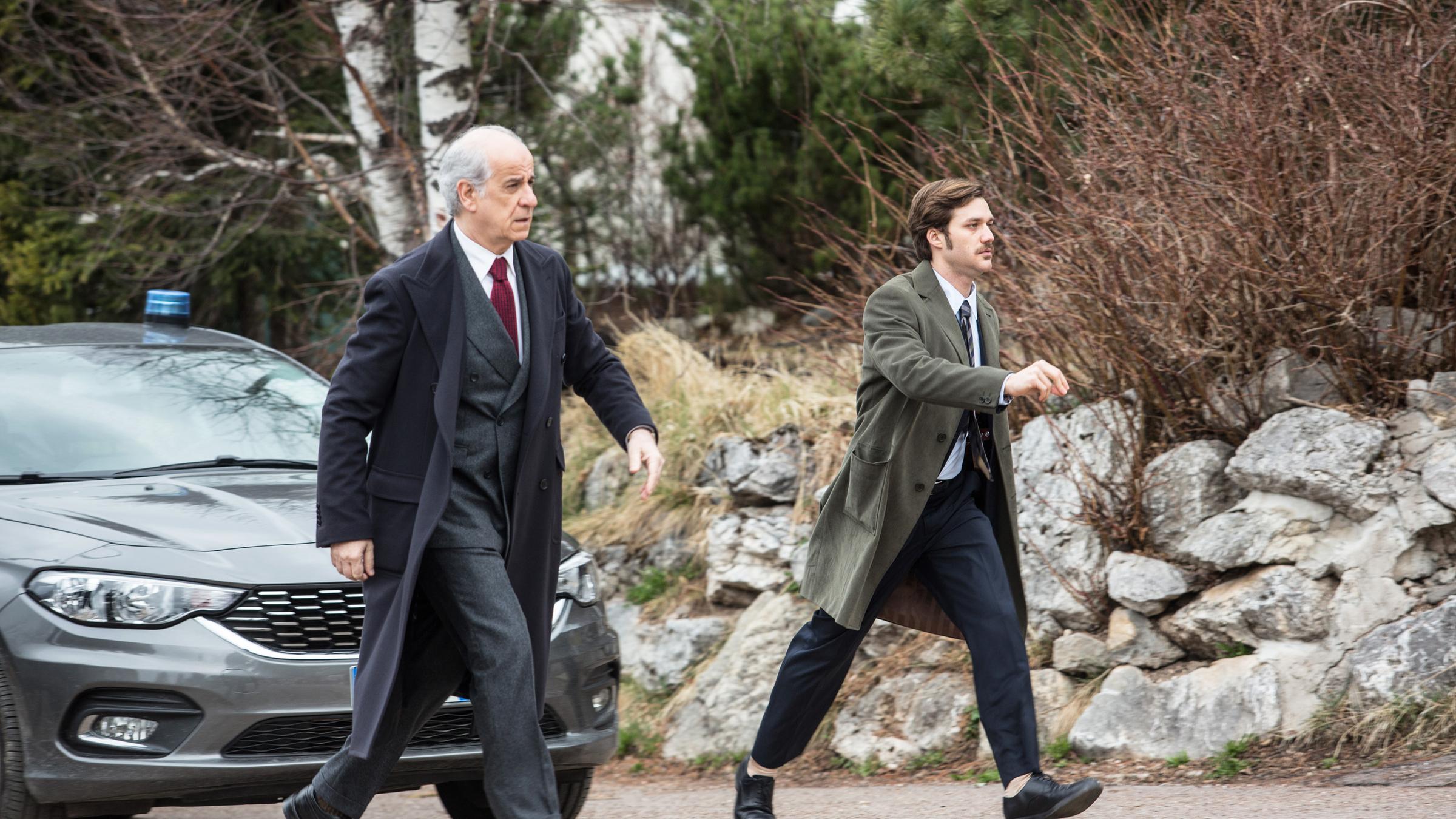 "Der Nebelmann": Sonderermittler Vogel (Toni Servillo) und sein Assistent Borghi (Lorenzo Richelmy) laufen einen Weg entlang. Hinter ihnen steht ein Wagen.