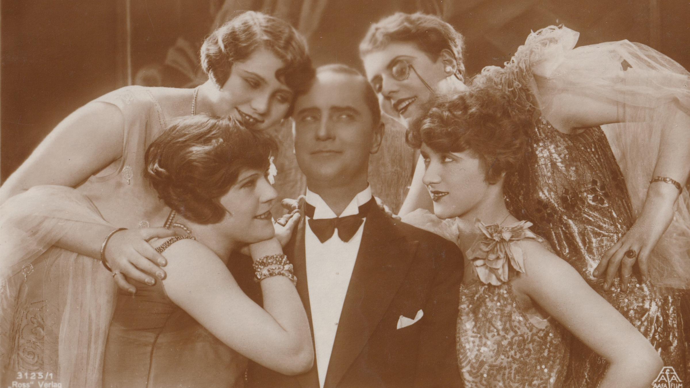 "Sündenbabel Berlin - Traumfabrik und Todesengel": Schwarz-Weiß-Foto eines Mannes im Anzug, umgeben von vier Frauen in Abendkleidern.