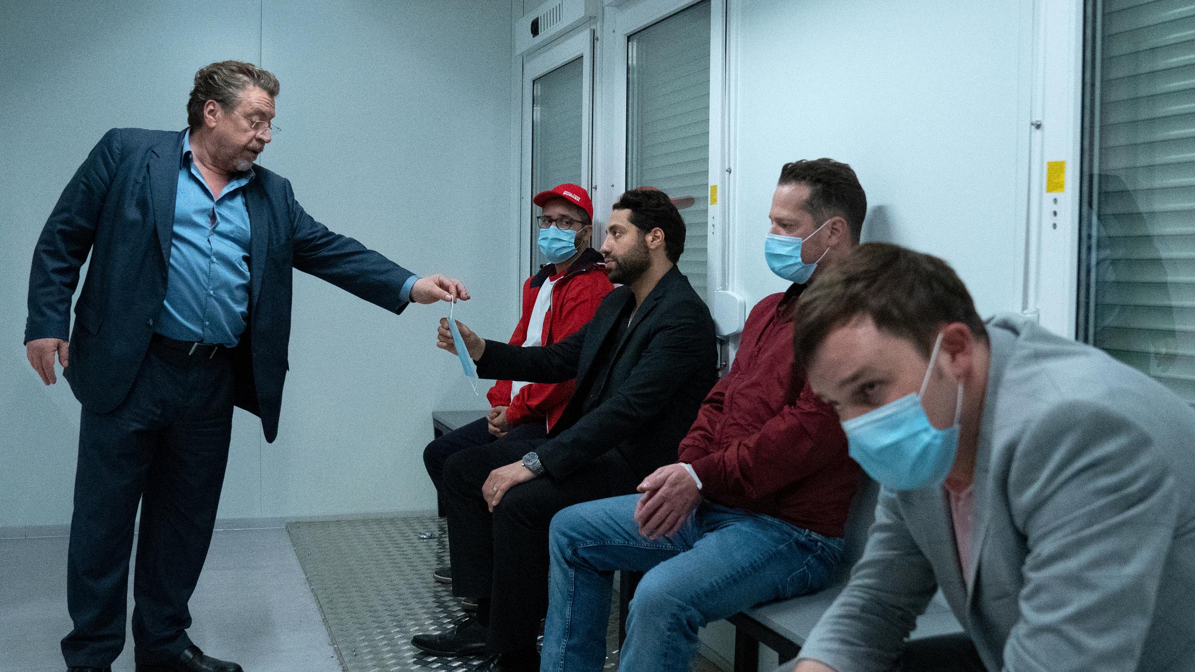 "Nachtschicht - Blut und Eisen": Park (Navid Navid), Mübariz Pettekaya (Kais Setti), Kevin Kruse (Aurel Manthei) und Mike Steiner (Frederic Linkemann) sitzen nebeneinander auf einer Bank. Erichsen (Armin Rohde) steht vor Ihnen und zeigt Mübariz Pettekaya (Kais Setti) ein Schriftstück.