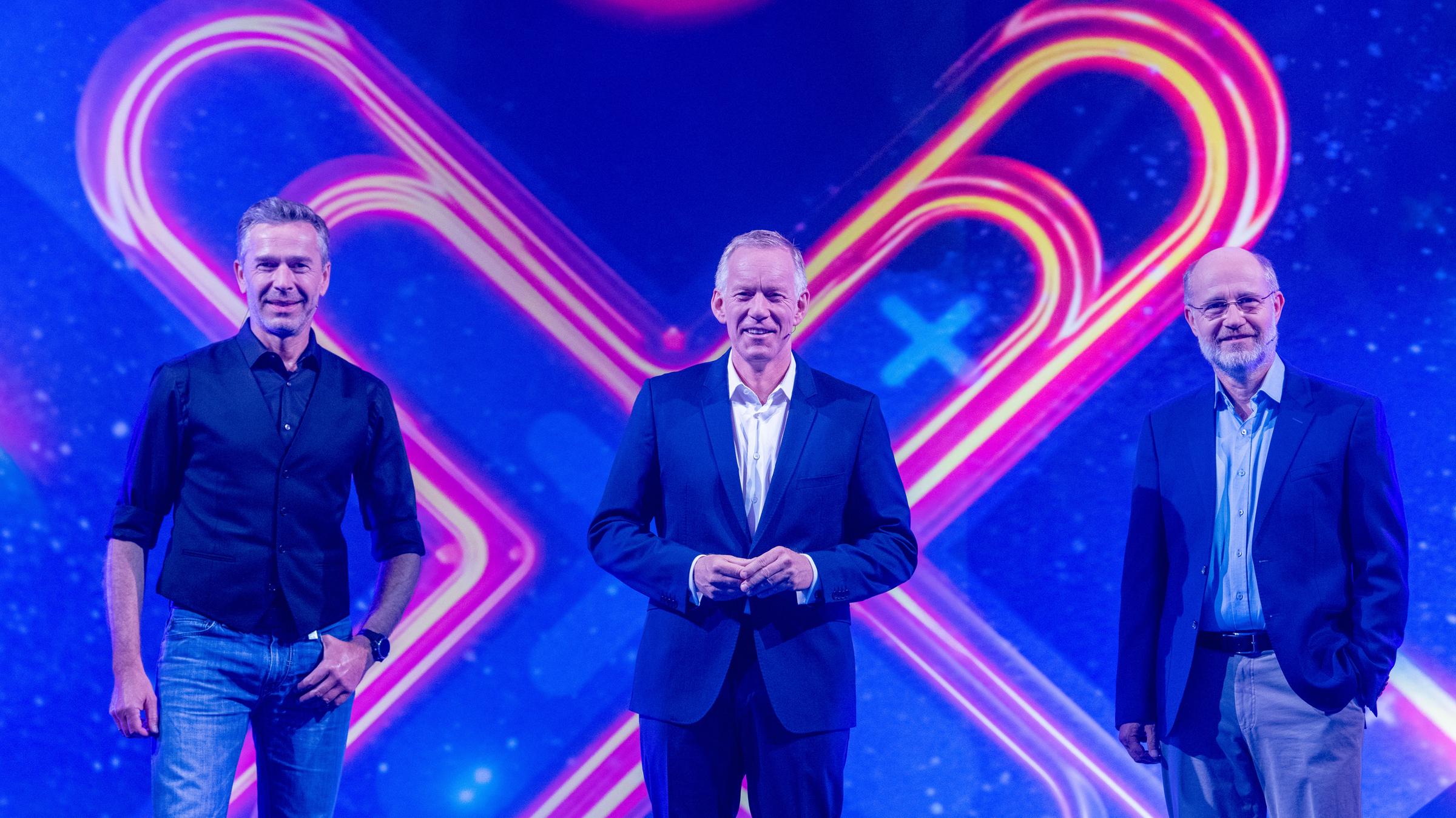 "Die große "Terra X"-Show - Mythen der Welt": Dirk Steffens, Johannes B. Kerner und Harald Lesch stehen im Studio vor "X" von "Terra X" auf LED-Wand im Studio und lächeln in die Kamera.