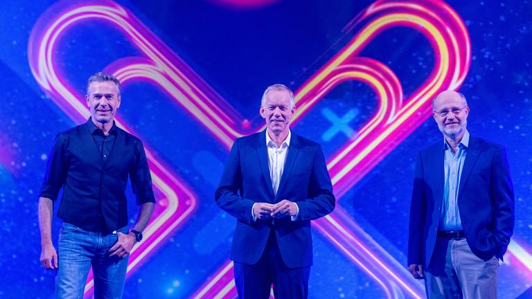 "Die große "Terra X"-Show - Mythen der Welt": Dirk Steffens, Johannes B. Kerner und Harald Lesch stehen im Studio vor "X" von "Terra X" auf LED-Wand im Studio und lächeln in die Kamera.