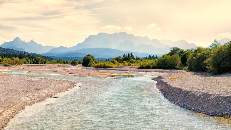 "Das Rauschen der Isar": Blick auf die Isar, die sich in Richtung Karwendelgebirge, das man im Hintergrund sieht, entlangschlängelt.