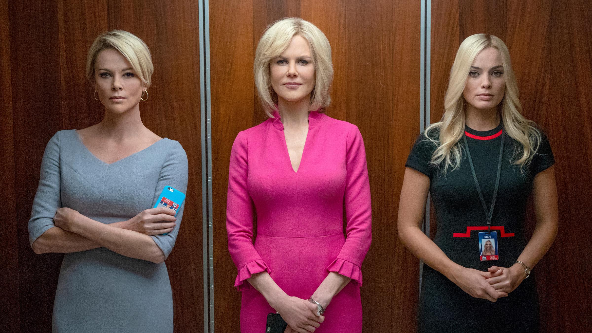 "Bombshell - Das Ende des Schweigens": Gretchen Carlson (Nicole Kidman), Megyn Kelly (Charlize Theron) und Kayla Pospisil (Margot Robbie) stehen nebeneinander in einem offenen Fahrstuhl und blicken den Betrachter an. Gretchen Carlson trägt ein auffälliges, pinkfarbenes Kleid.