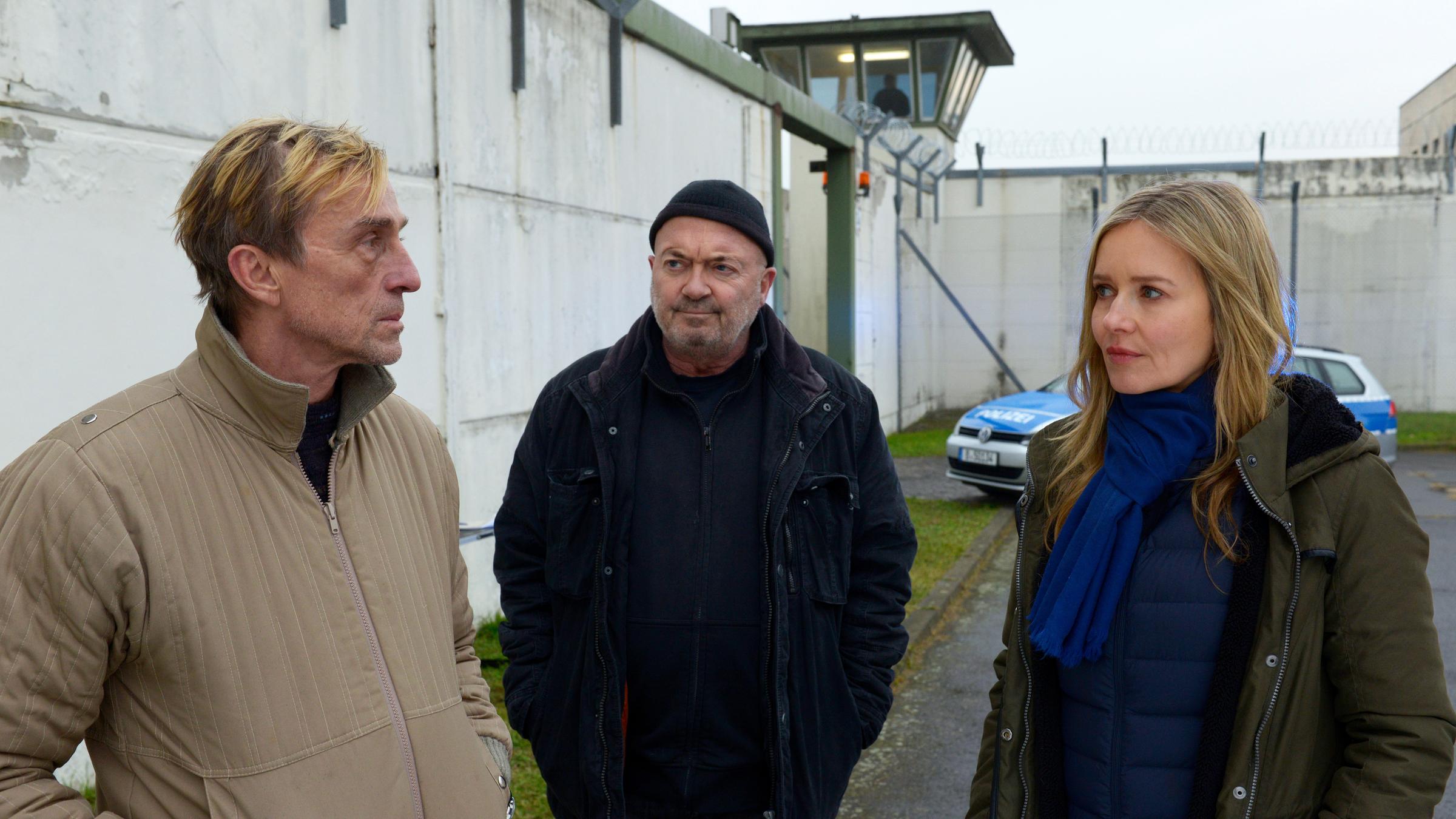 "Ein starkes Team - Verdammt lang her": Peter Kniesbeck (André M. Hennicke), Otto Garber (Florian Martens) und Linett Wachow (Stefanie Stappenbeck) stehen in einem Gefängnishof beisammen. Otto und Linett sehen zu Kniesbeck, der zu Linett schaut.
