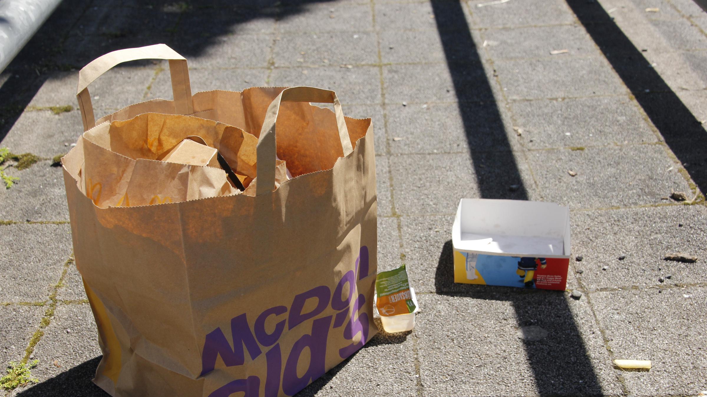 "planet e.: Fast Food - Das große Fressen": Müll nach dem Verzehr von Fast Food, der auf einer Straße liegt.