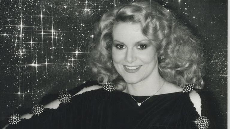 "Die Schlagerstory - Geliebt, gehasst und unterschätzt": Schwarz-Weiß-Foto. Peggy March sitzt vor einem glitzernden Hintergrund.