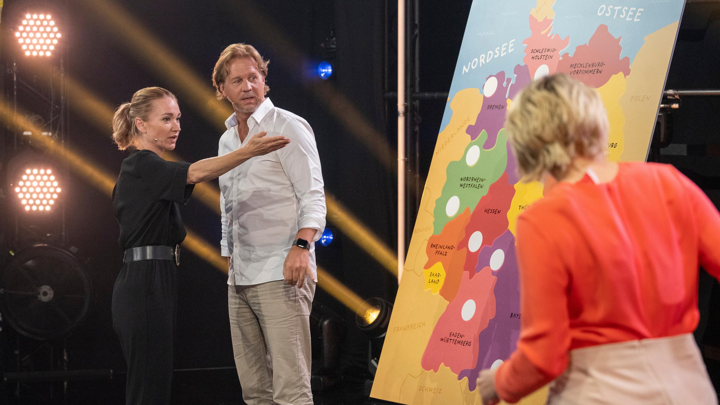 "Das große Deutschland-Quiz": Lisa Maria Potthoff und Thomas Heinze stehen an einer Deutschlandkarte. Sabine Heinrich ist von hinten zu sehen. Sie steht auf der anderen Seite an der Deutschlandkarte.