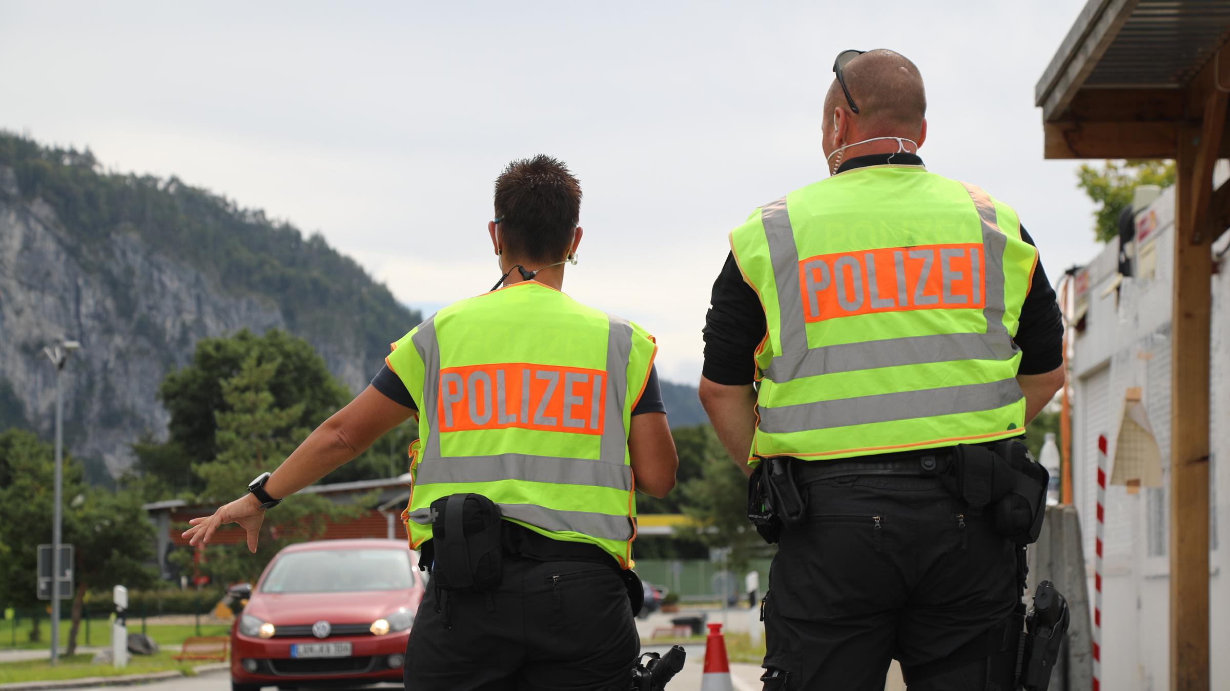 "ZDF.reportage: Dürfen die das - Coronaregeln und kein Ende": Zwei Polizeibeamten mit gelber Warnweste an einem Grenzübergang.