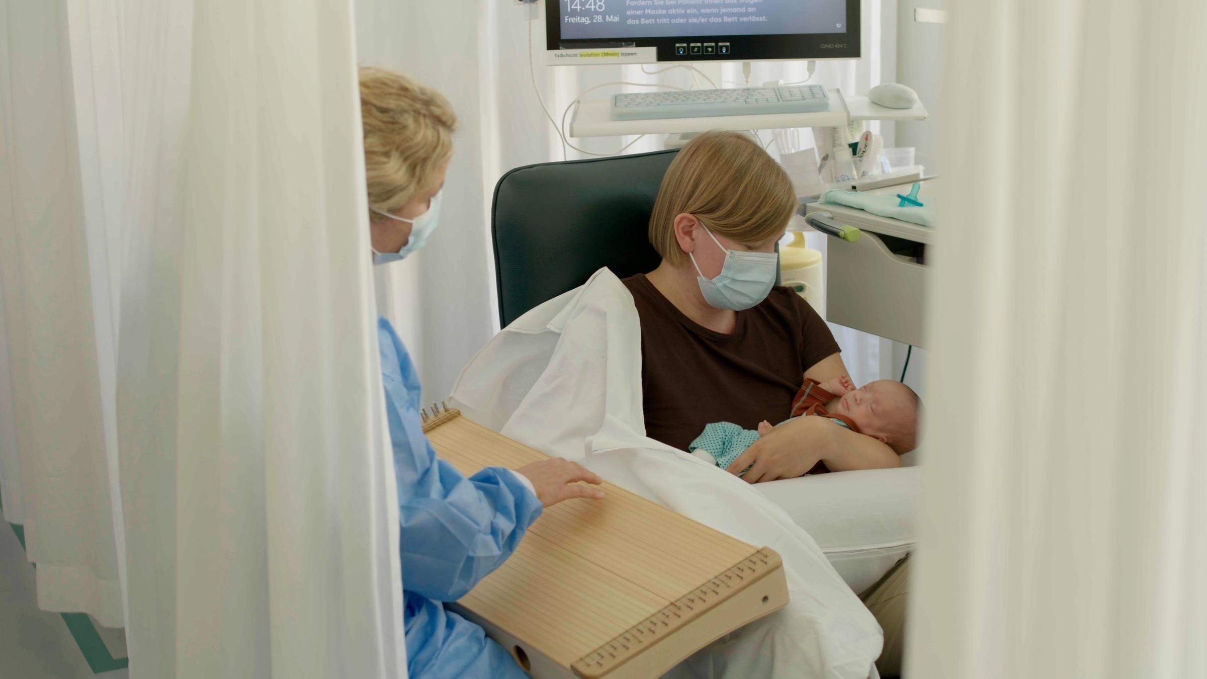 "Die Kraft der Klänge - Musik als Medizin": Frau spielt Monochord für Mutter und Baby auf Intensivstation.