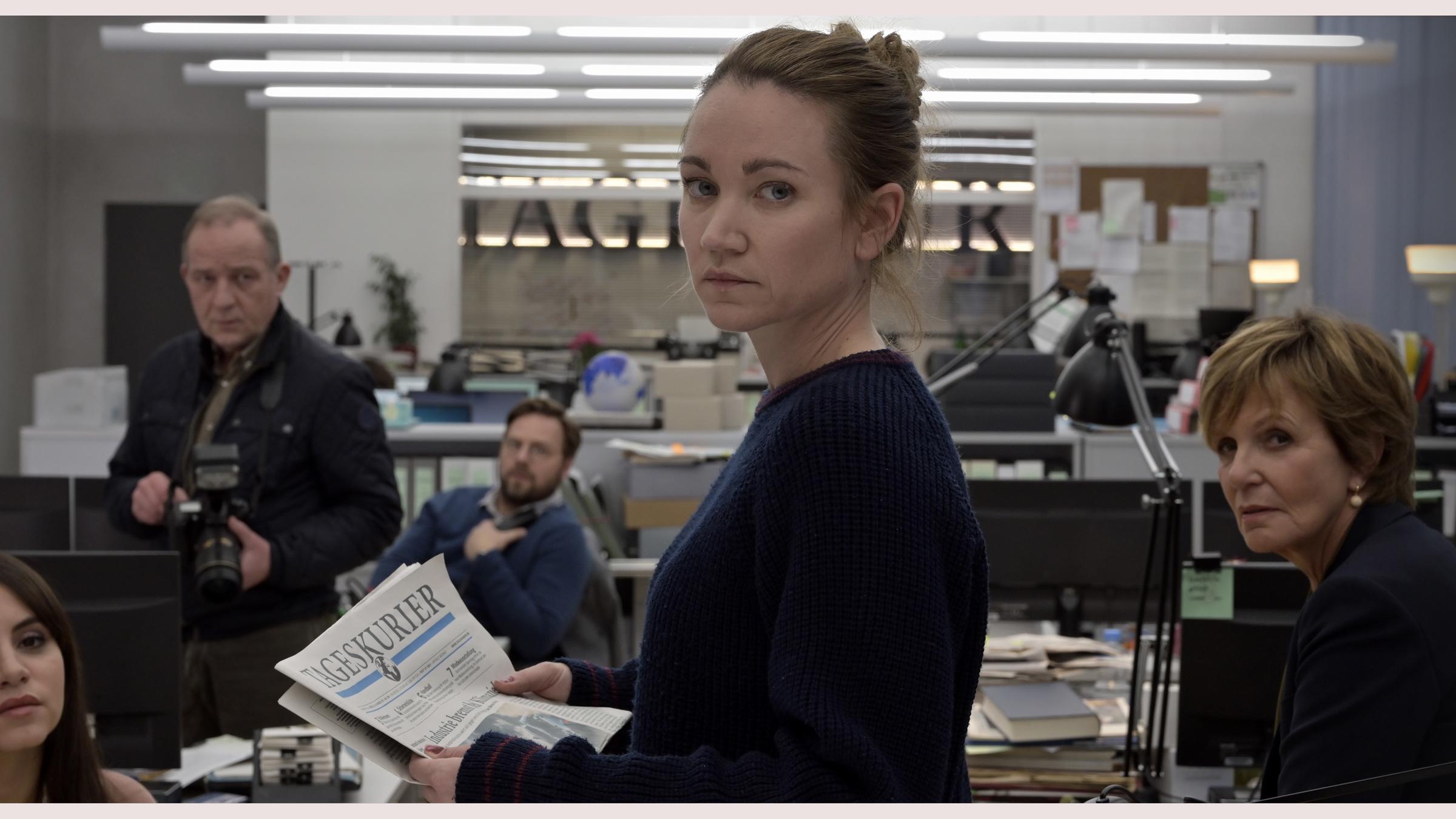 "Gefährliche Wahrheit": Blick in die Redaktionsräume des Tageskuriers. Die Mitarbeiter (Amila Bagriacik, Uwe Preuss, Christoph Letkowski, Ulrike Kriener) haben sich um ihre Kollegin Maren Gehrke (Lisa Maria Potthoff) versammelt. Sie hält eine Ausgabe der Zeitung in den Händen und blickt über die Schulter in Richtung der Kamera.