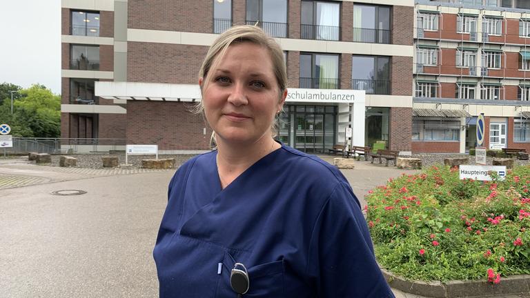 "plan b: Die Unentbehrlichen - Mehr Anerkennung für harte Arbeit": Krankenpflegerin Kerstin Leib steht vor dem Gebäude der Universitäts- und Rehabilitationskliniken Ulm.