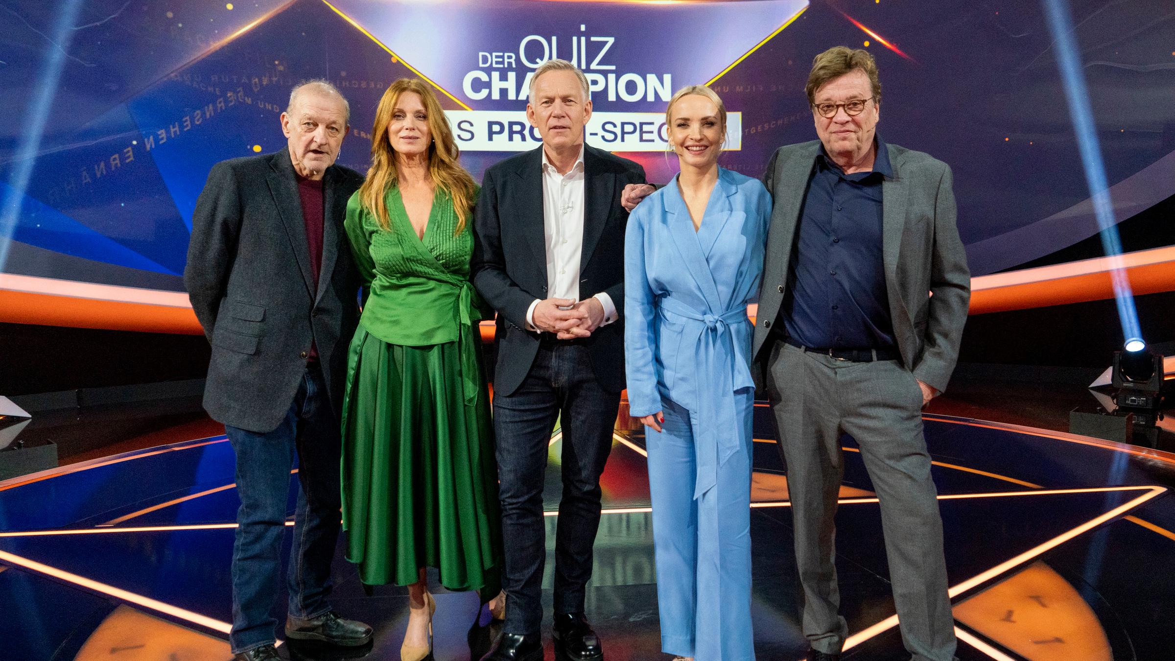 "Der Quiz-Champion - Das Promi-Special": Promi-Kandidaten Leonard Lansink, Esther Schweins, Moderator Johannes B. Kerner, Promi-Kandidaten Janin Ullmann und Béla Réthy stehen vor dem Sendungslogo im Studio und lachen in die Kamera.