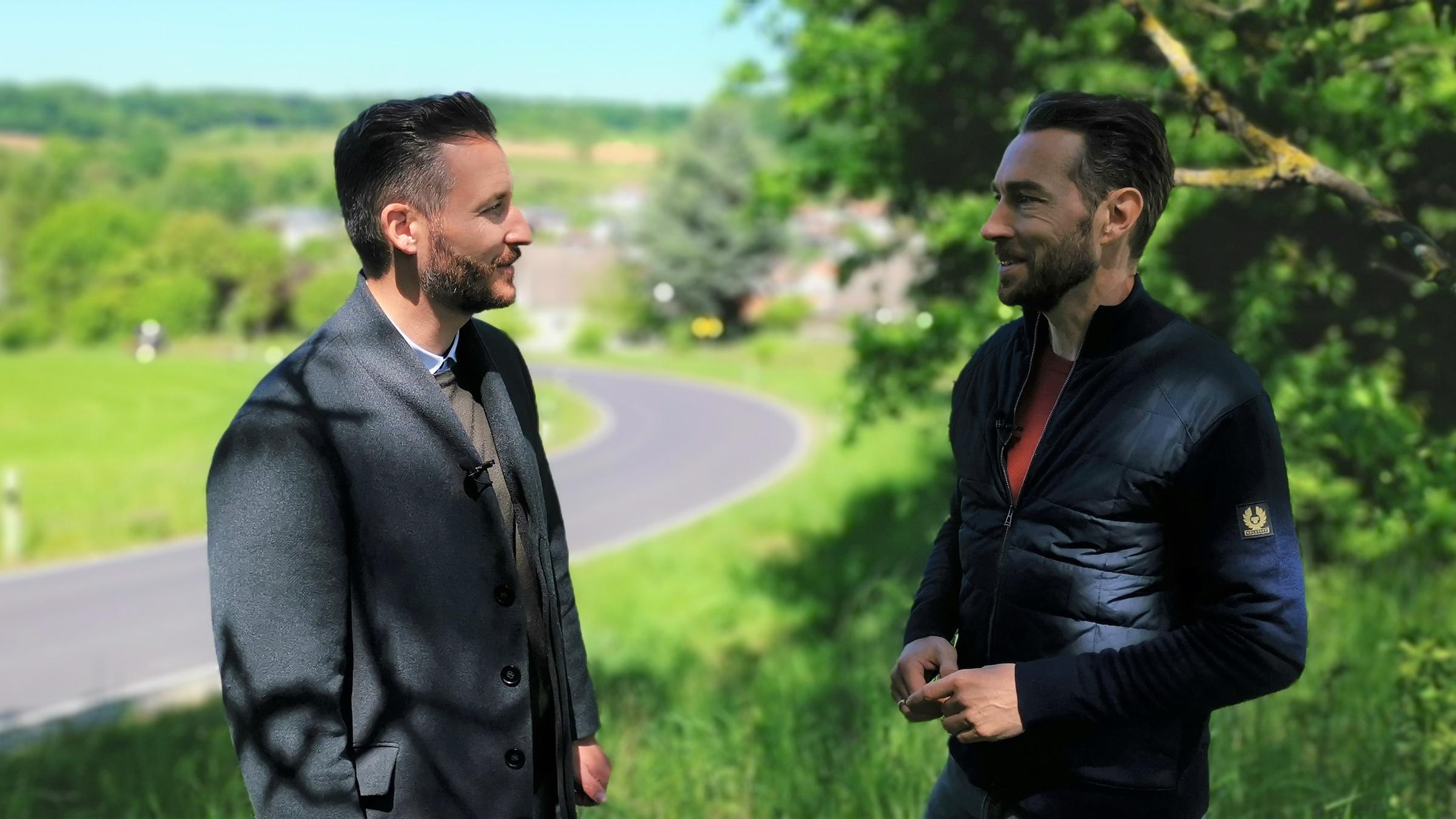 "XY gelöst": Staatsanwalt Thomas Hauburger und Sven Voss stehen tagsüber gemeinsam am Straßenrand einer Landstraße und unterhalten sich. Im Hintergrund ist ein Ortschaft.