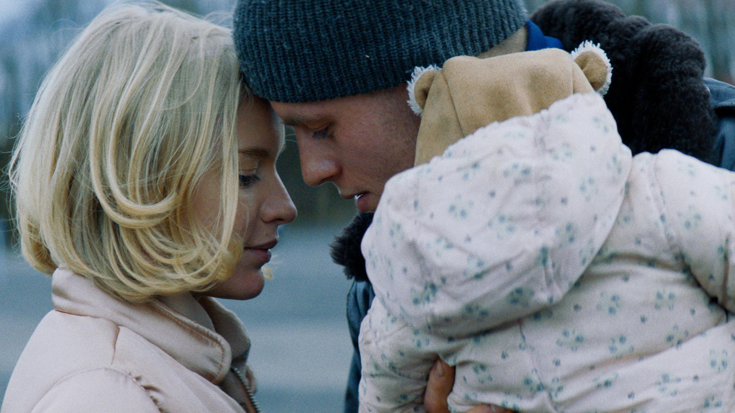 "Kids Run": Andi (Jannis Niewöhner) und seine Ex-Freundin Sonja (Lena Tronina) stehen mit gesenktem Blick dicht voreinander, ihre Stirnen berühren sich. Andi hält seine kleine Tochter Fiou (Sophia Demer) auf dem Arm.