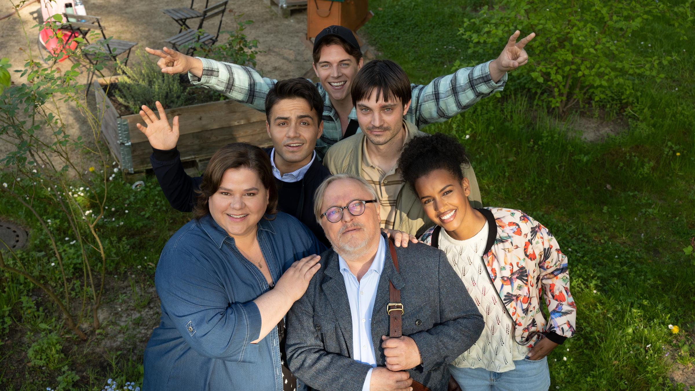 "Extraklasse – On Tour": Ralph (Axel Prahl) und seine Schüler:innen posieren für ein Gruppenfoto. In der vordersten Reihe stehen Ruth (Nadine Wrietz), Ralph und Faheema (Belina Mohamed-Ali). Dahinter folgen Keywan (Aram Arami) und Mirco (Niklas Bruhn). Ganz hinten steht Nick (Gerrit Klein).