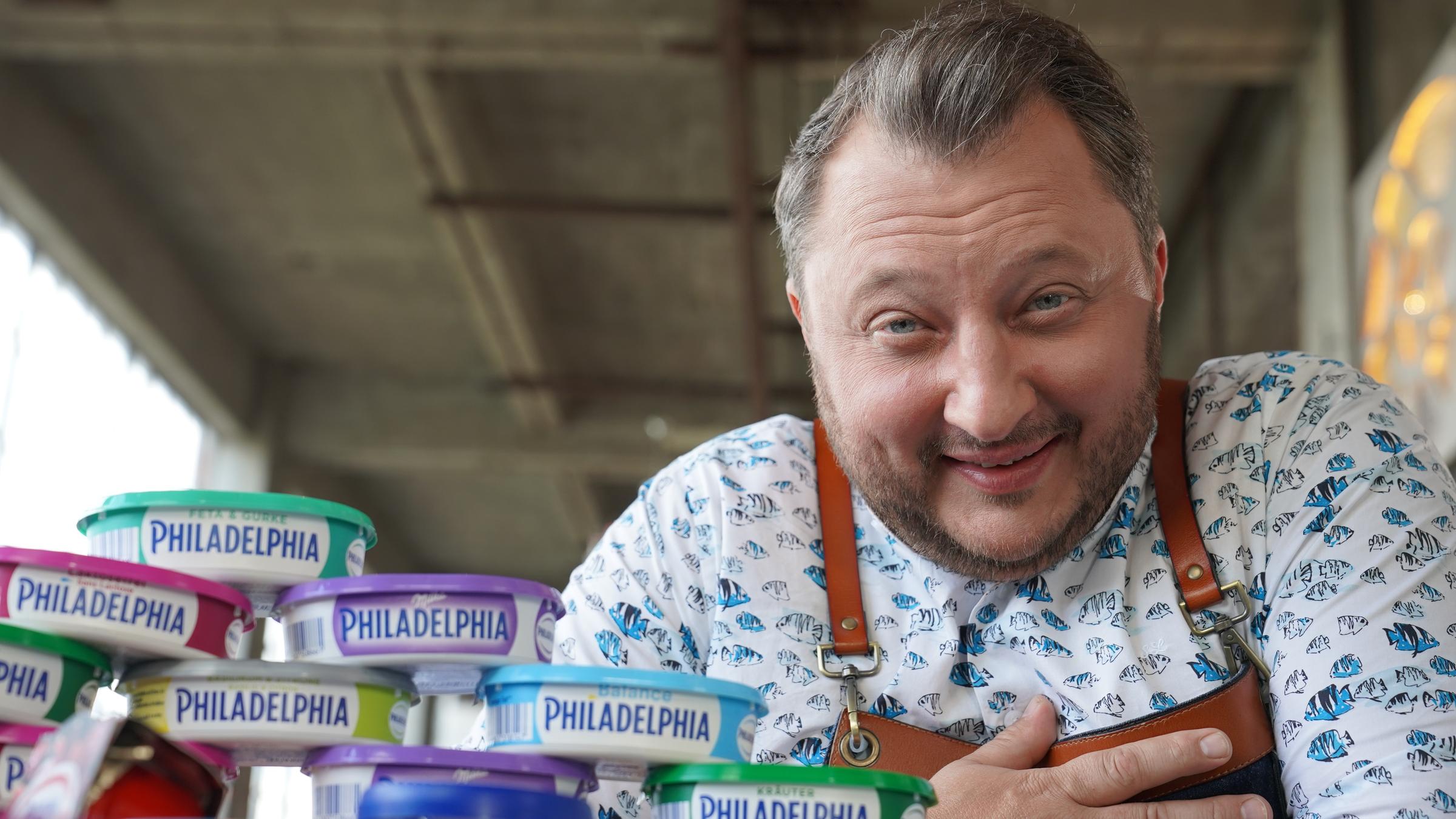 "ZDFzeit: Tricks der Lebensmittelindustrie mit Sebastian Lege: Milka, Oreo, Philadelphia": Sebastian Lege in seiner Werkstatt vor Produkten und Zutaten von Unilever.