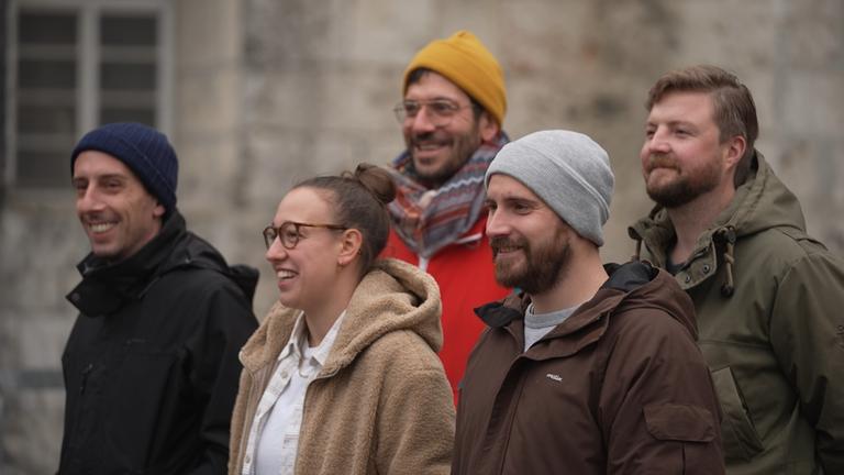 "plan b: Ein Dach für alle - Wege aus der Obdachlosigkeit": Fünf Sozialarbeiter stehen vor einem Gebäude in Ulm.