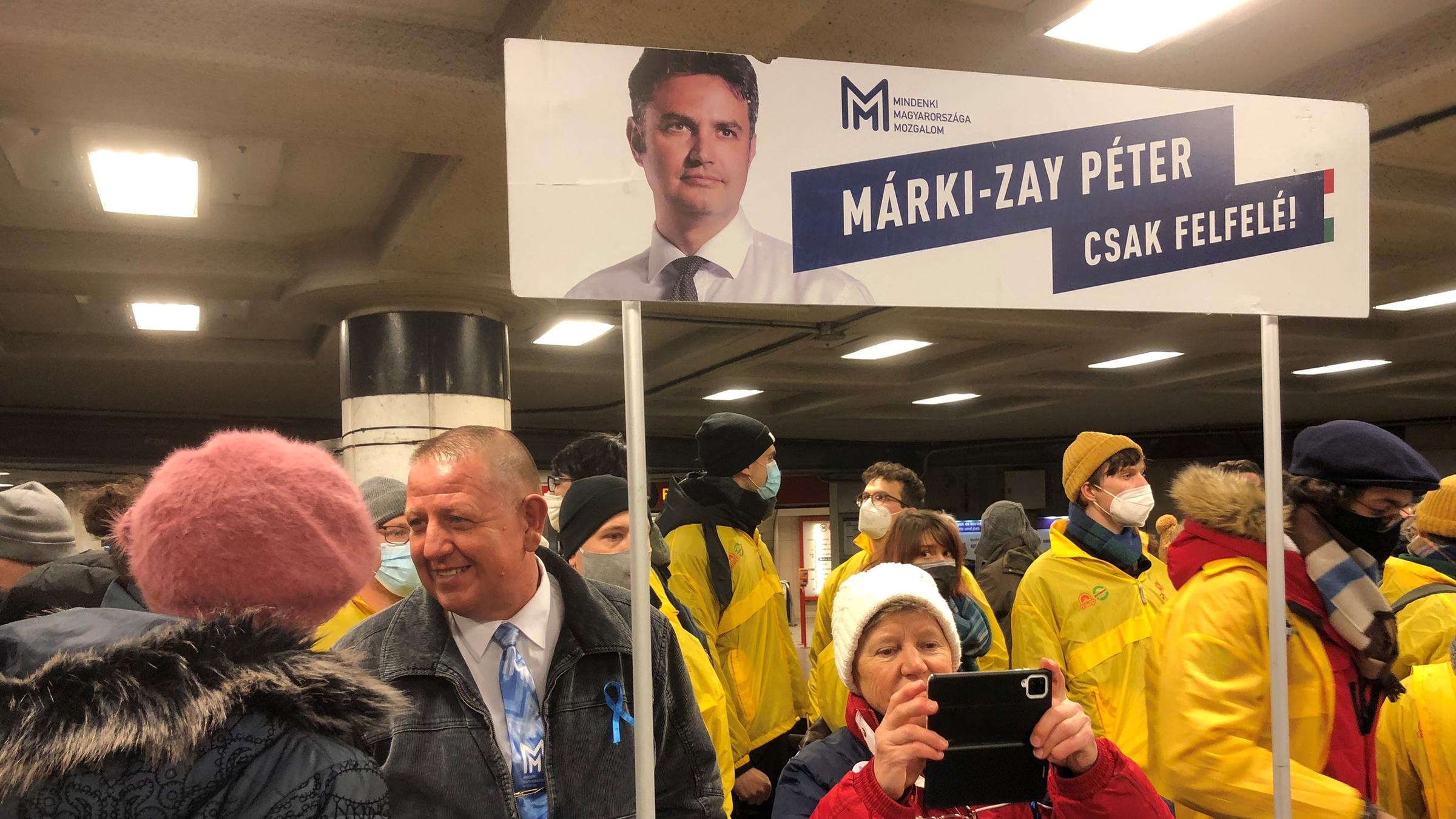 "Gegenwind für Viktor Orbán": kleine Menschenansammlung mit Plakat