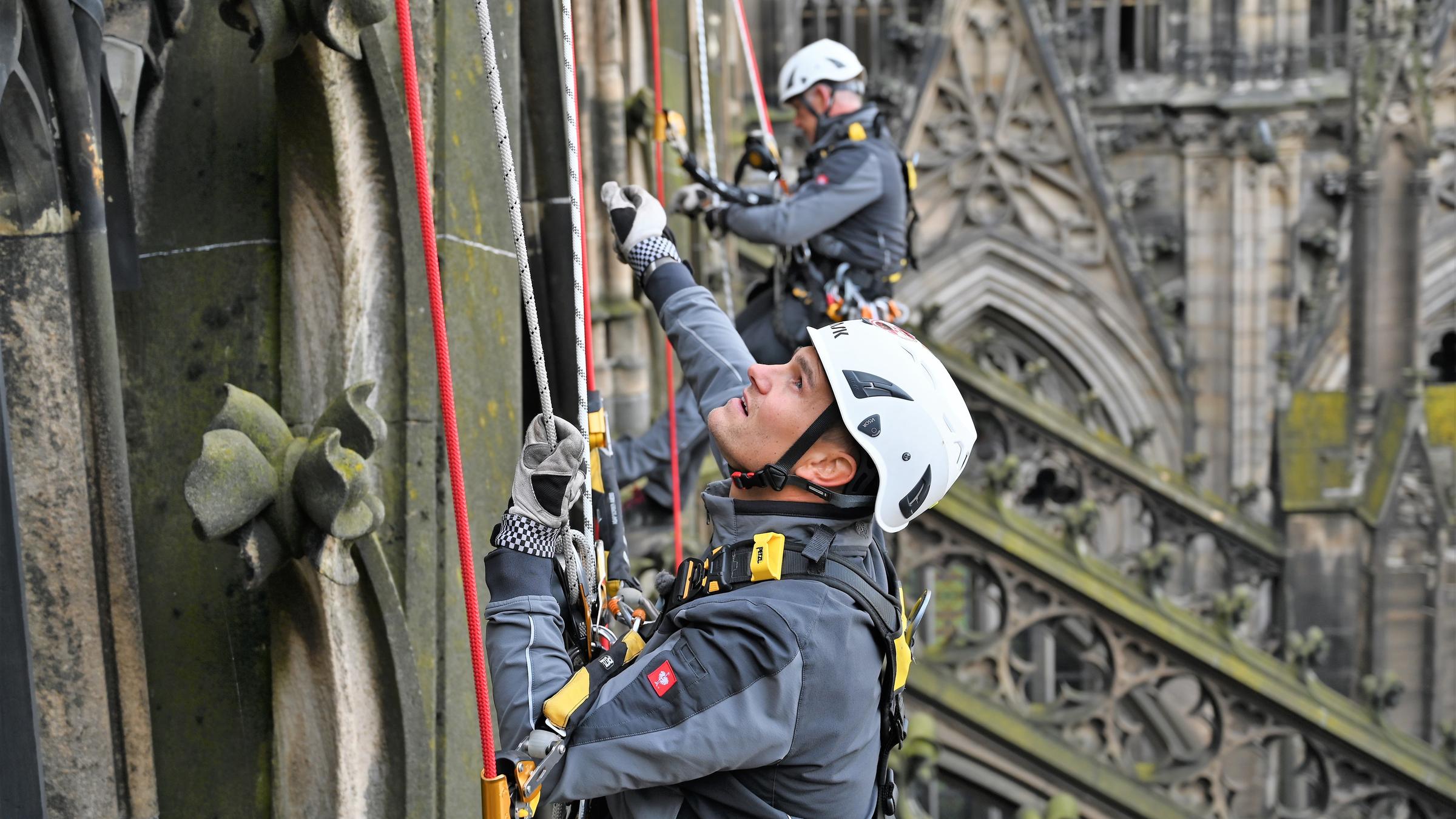 "37° Job mit Ausblick - Arbeiten in luftigen Höhen": Zwei Industriekletterer hängen an der Nordfassade des Kölner Doms.