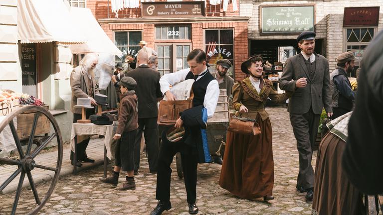 "Terra X: Ein Tag in New York 1882": Spielszene: Georg Schmidt (Leon Blaschke) geht durch einen Markt in "Little Germany".