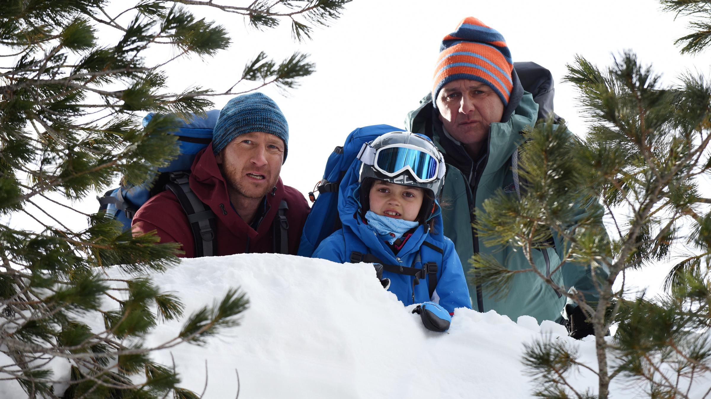"Der Bergdoktor: Kalte Stille":  Über eine schneebedeckten Bergklippe blicken Flora (Yuna Bennet), Martin (Hans Sigl) und Hans (Heiko Ruprecht) entsetzt in die Tiefe.