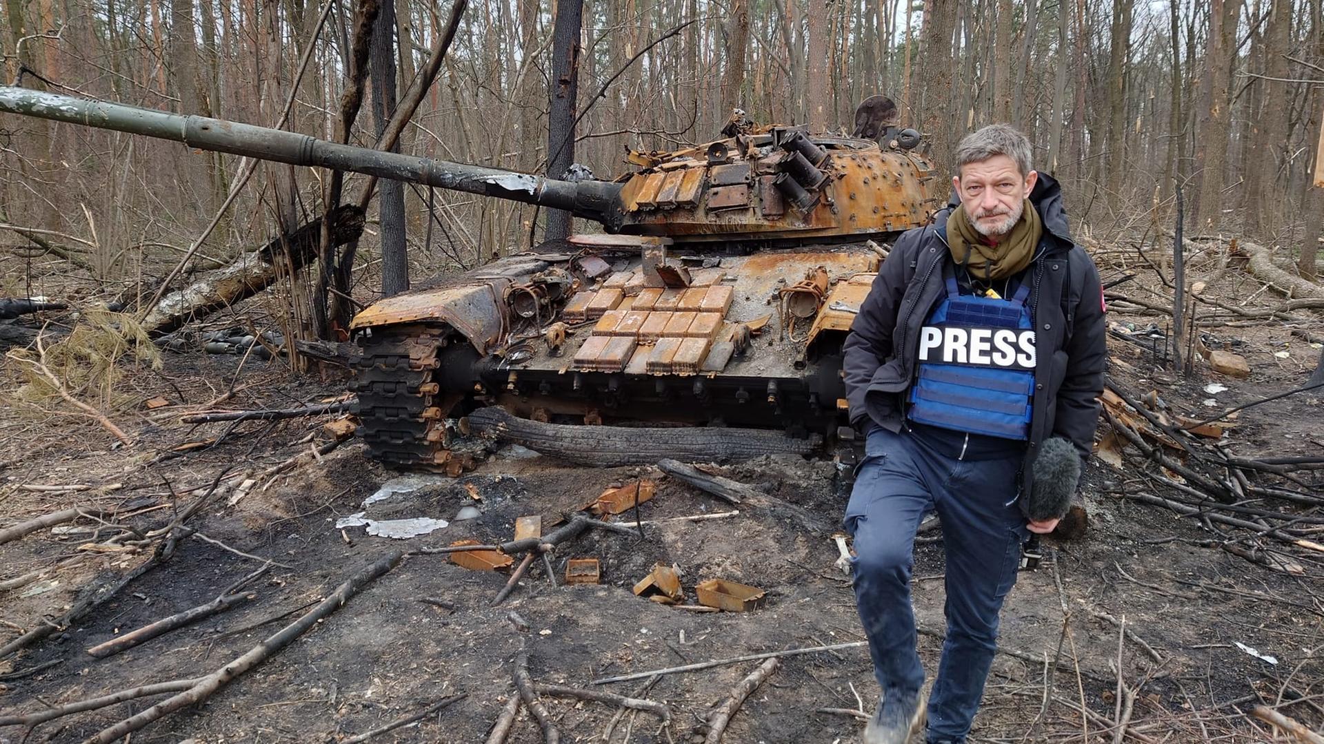 "frontal-Dokumentation: Die Straße des Todes - Kriegsverbrechen in der Ukraine": Reporter Arndt Ginzel vor russischen Panzer.