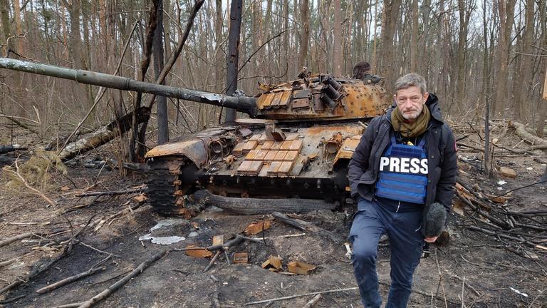 "frontal-Dokumentation: Die Straße des Todes - Kriegsverbrechen in der Ukraine": Reporter Arndt Ginzel vor russischen Panzer.