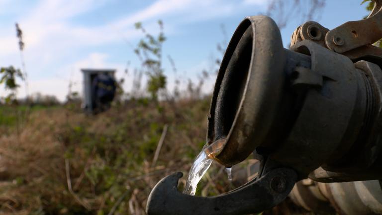 "planet e.: Wassernot? Auf der Suche nach neuen Quellen": Nahaufnahme. Wenig Wasser fließt aus einer Pumpe auf einem Feld.