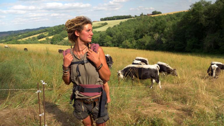 "plan b: Land für alle - Im Kampf gegen Spekulanten": Anousha Zähringer steht auf ihrer Weide mit ihren Vogesenrindern im Hintergrund.