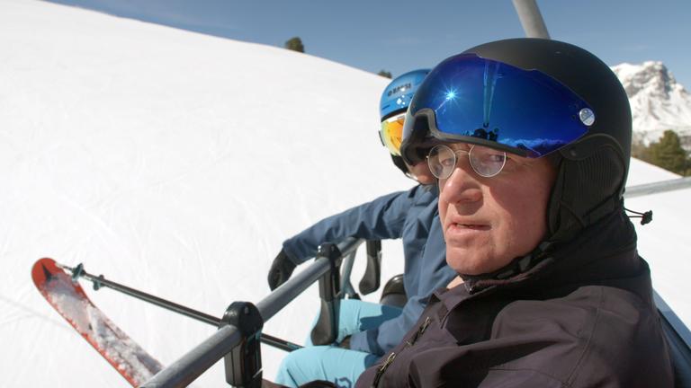 "ZDFzeit: Mensch Gysi! Grenzgänger zwischen Ost und West": Gregor Gysi mit Skihelm in einem Skilift vor winterlicher Landschaft.