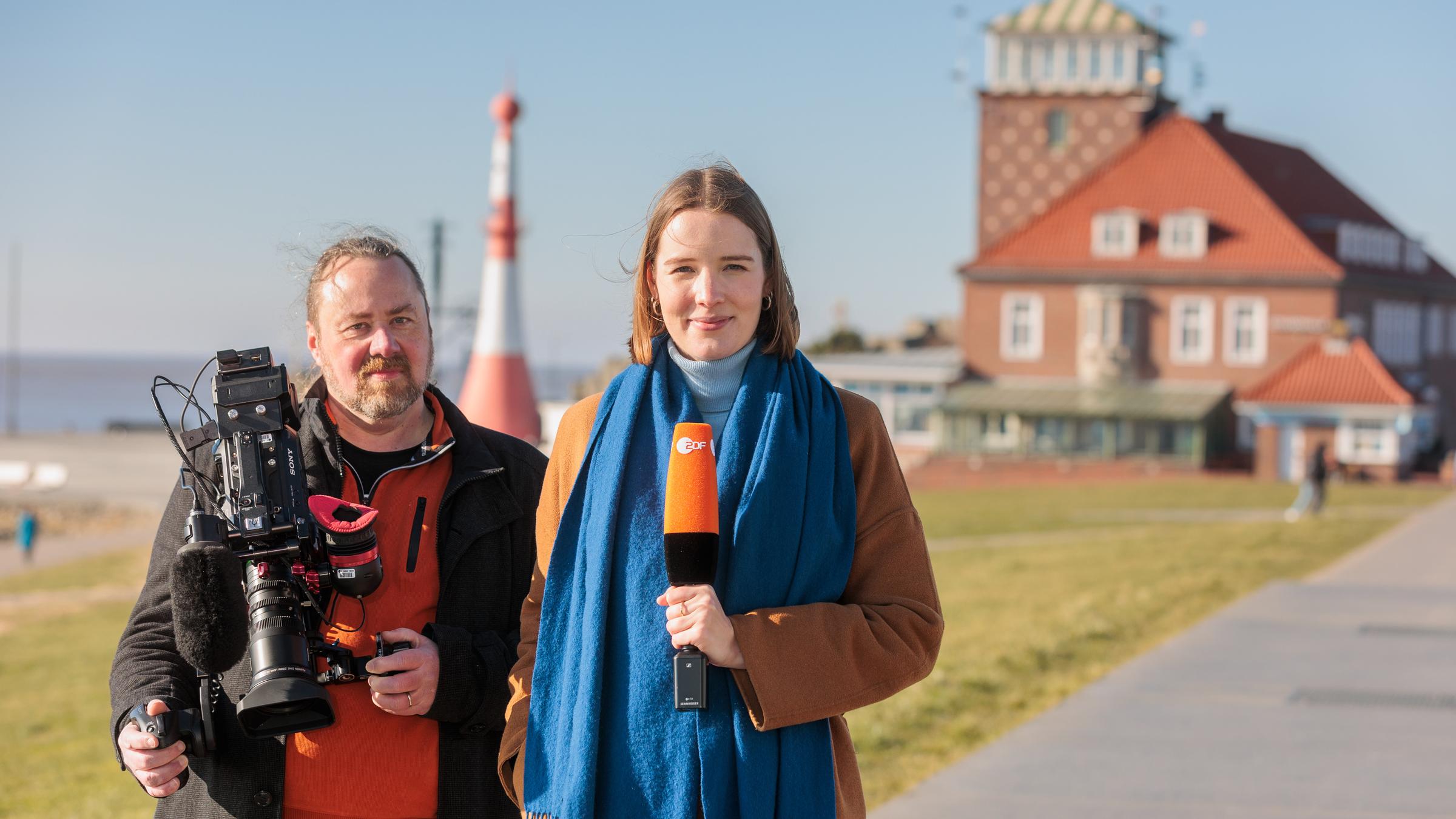 ZDF-Reporterin Ruth de Carné und Kameramann und Cutter Thomas Henke stehen an einem Deich in Bremerhaven.