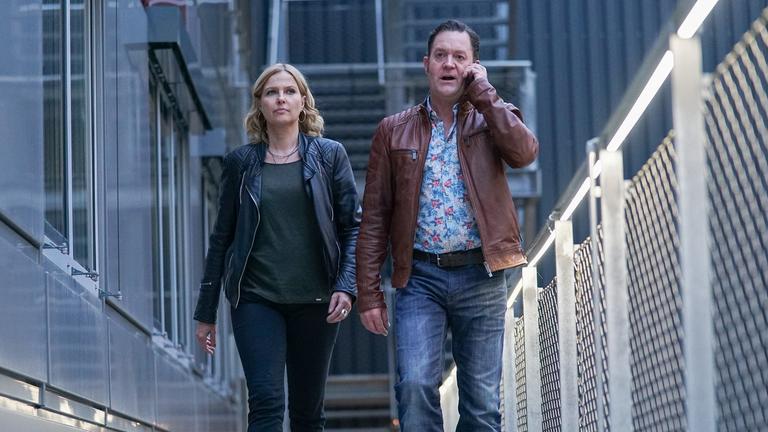 "Die Chefin – Glück": Vera Lanz (Katharina Böhm) und der telefonierende Paul Böhmer (Jürgen Tonkel) gehen nebeneinander an einem Gebäude entlang.