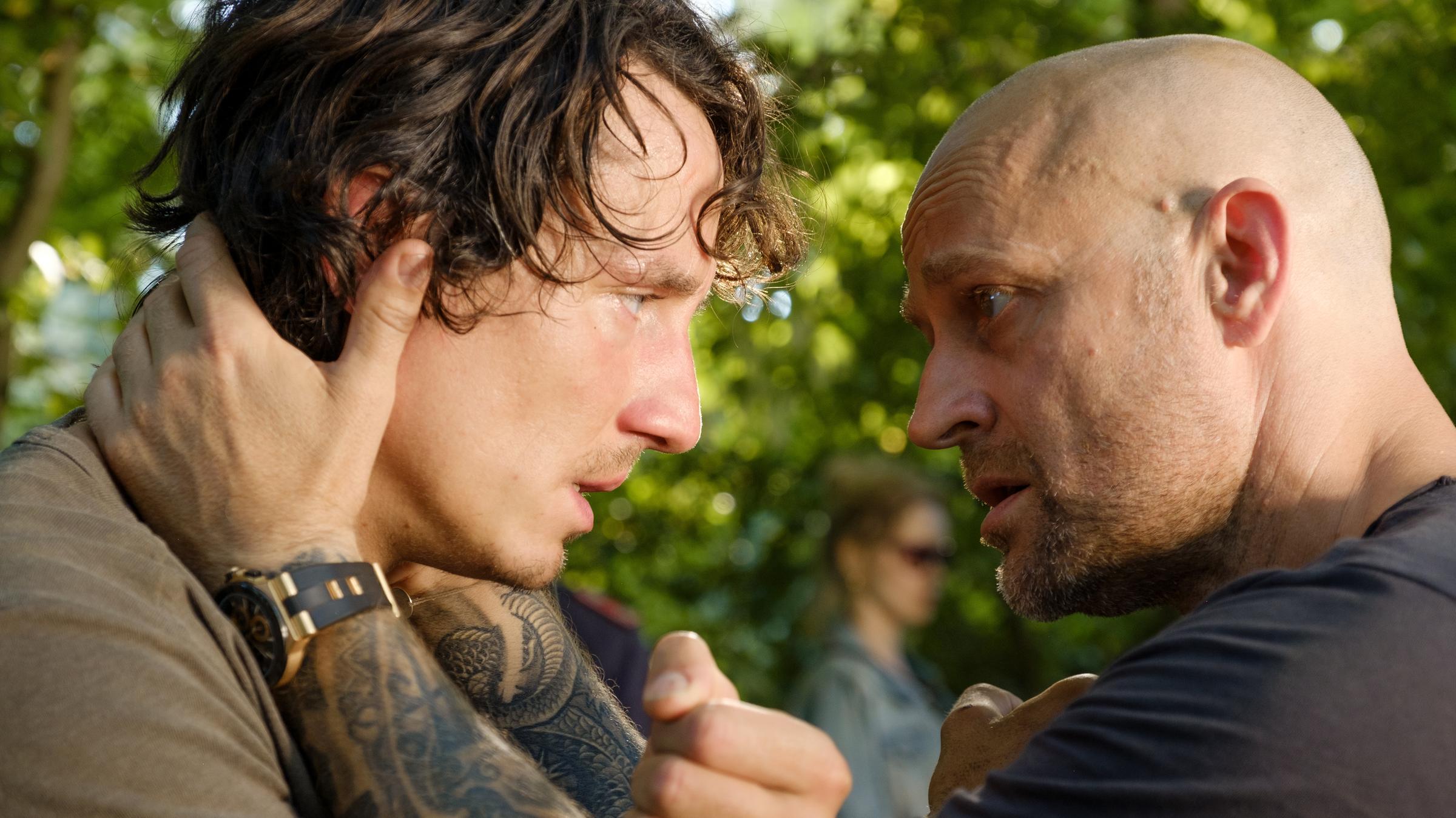 "BROLL + BARONI - Für immer tot": Kai Baroni (Jürgen Vogel) hat seine Hände an den Hals des aufgebrachten Max Broll (Laurence Rupp) gelegt und sieht ihm eindringlich in die Augen.