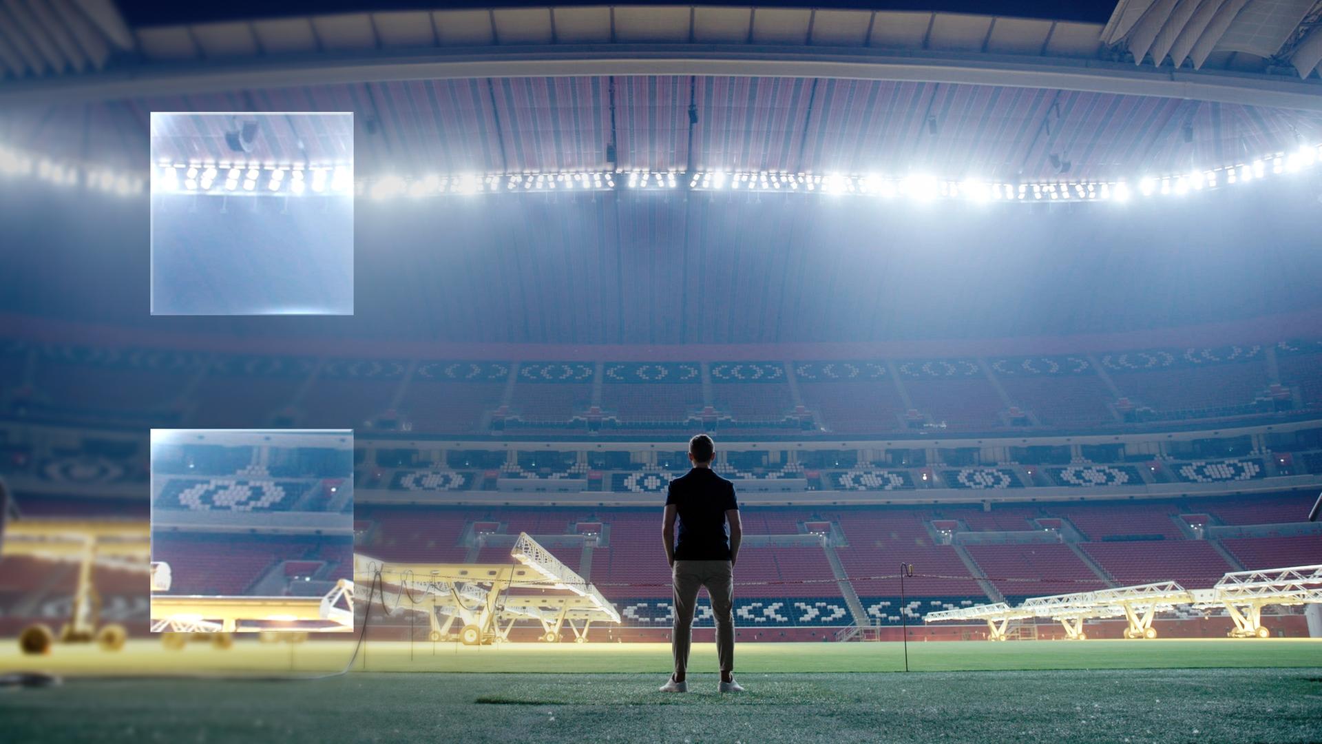 "ZDFzeit: Geheimsache Katar": Blick in ein leeres, hell beleuchtetes Fußballstadion. In der Mitte sind die dunklen Umrisse eines Menschen zu erkennen, der dem Betrachter den Rücken zukehrt