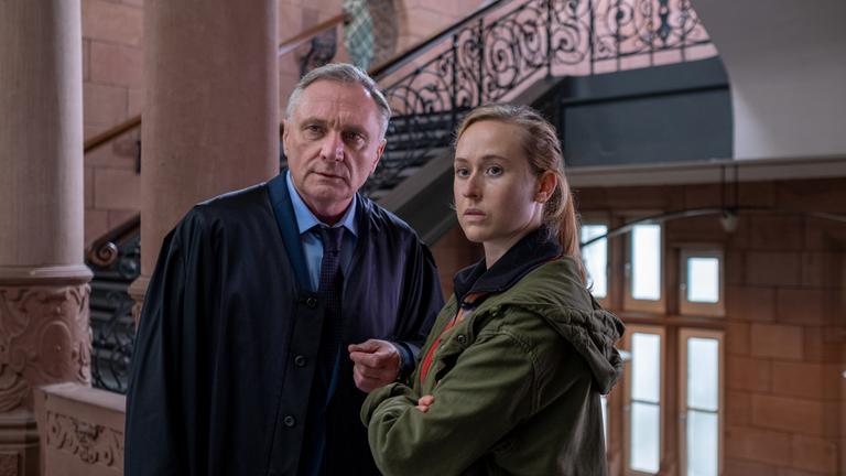 "Der Kommissar und der See - Liebeswahn": Thomas Wagner (Bernhard Schir) und Annika Wagner (Nurit Hirschfeld) stehen nebeneinander in einem Treppenhaus.