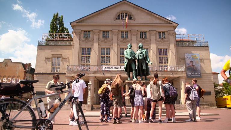 "Weimar - Zwischen Prunk und Platte": Eine Schulgruppe steht um das Goethe-Schiller-Denkmal herum.
