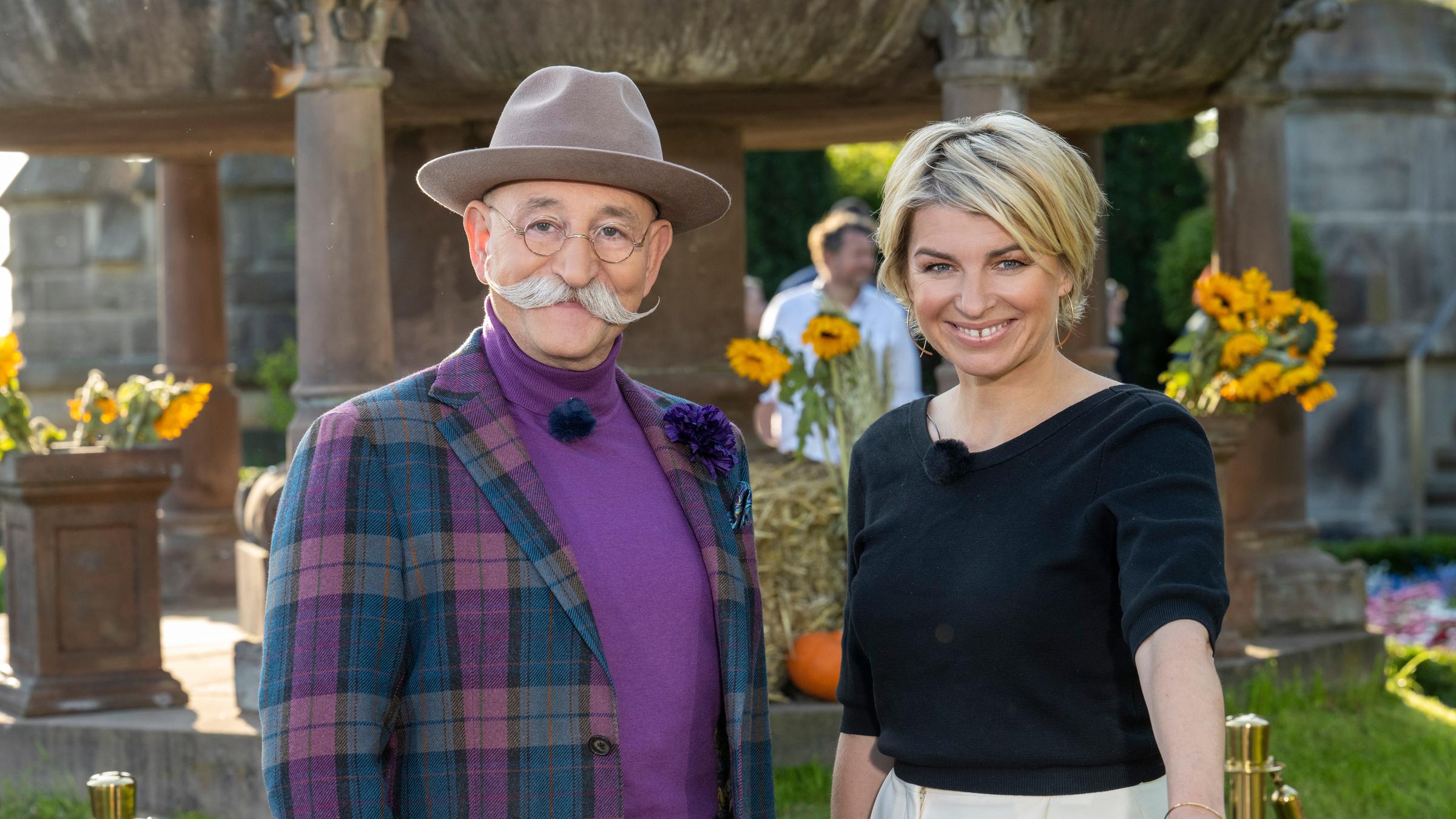 "Bares für Rares - Deutschlands größte Trödelshow": Horst Lichter und Sabine Heinrich stehen hinter einem Expertisentisch und lächeln in die Kamera.