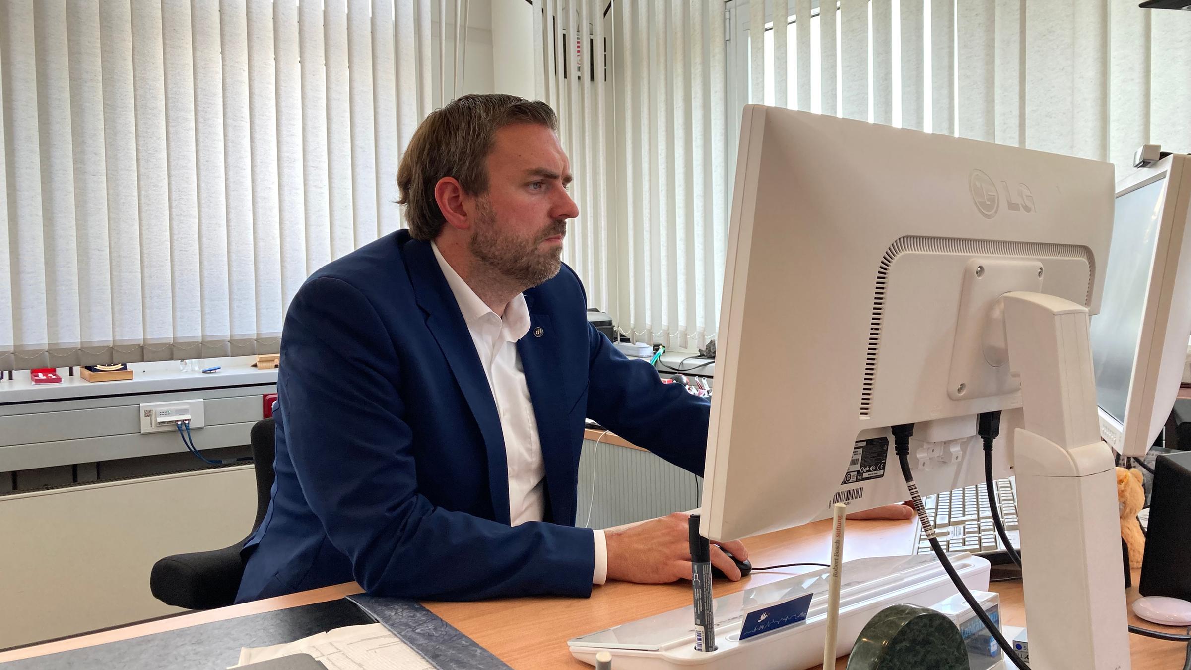 "Engagiert und attackiert - Wenn Politiker zur Zielscheibe werden": Erik Lierenfeld, Bürgermeister von Dormagen, sitzt an seinem Schreibtisch.