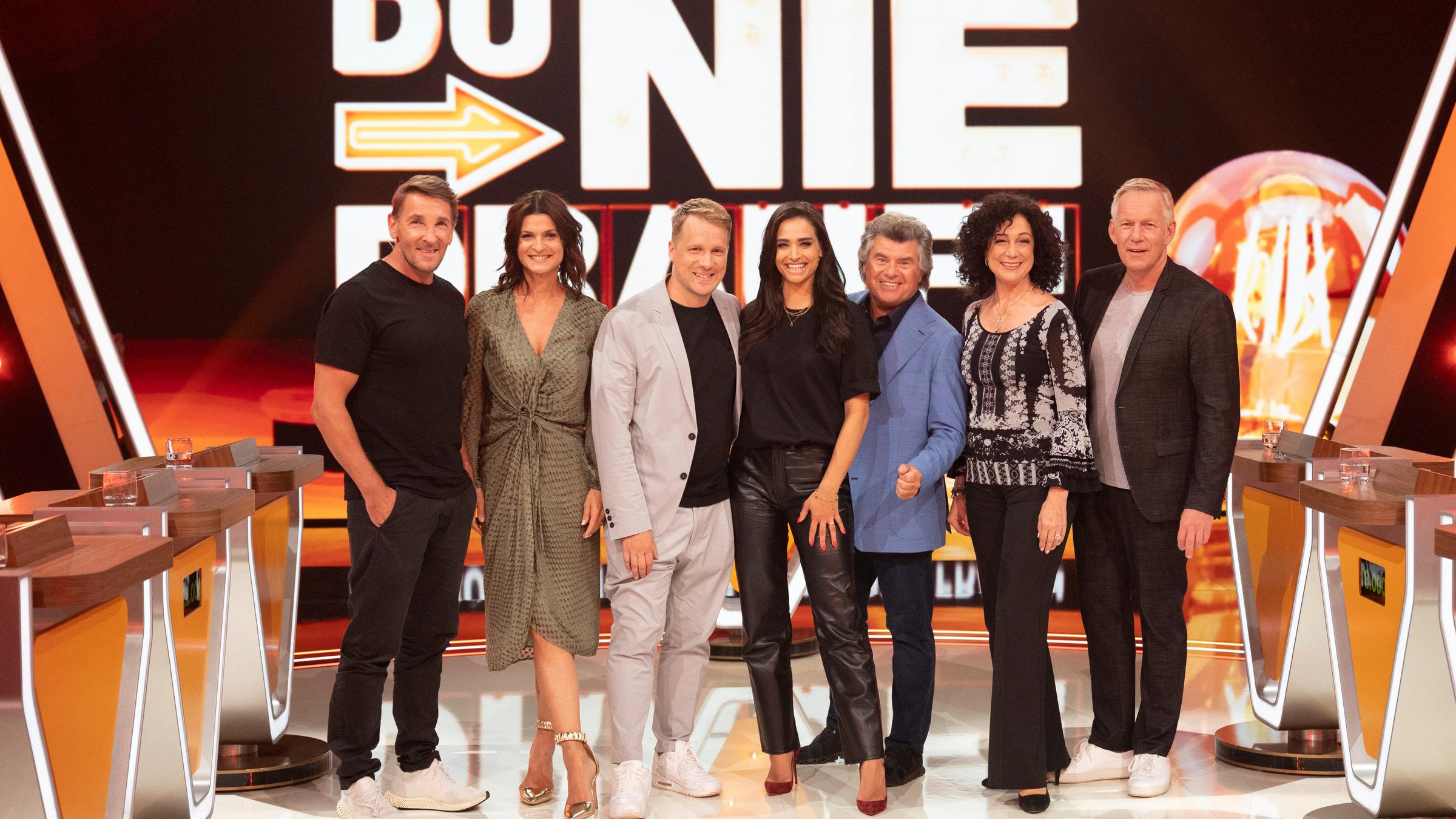 "Da kommst Du nie drauf!": Mark Keller, Marlene Lufen, Oliver Pocher, Amira Pocher, Andy Borg, Barbara Wussow und Johannes B. Kerner stehen für ein Gruppenfoto im Studio vor der Videowand. Im Hintergrund das Sendungslogo.