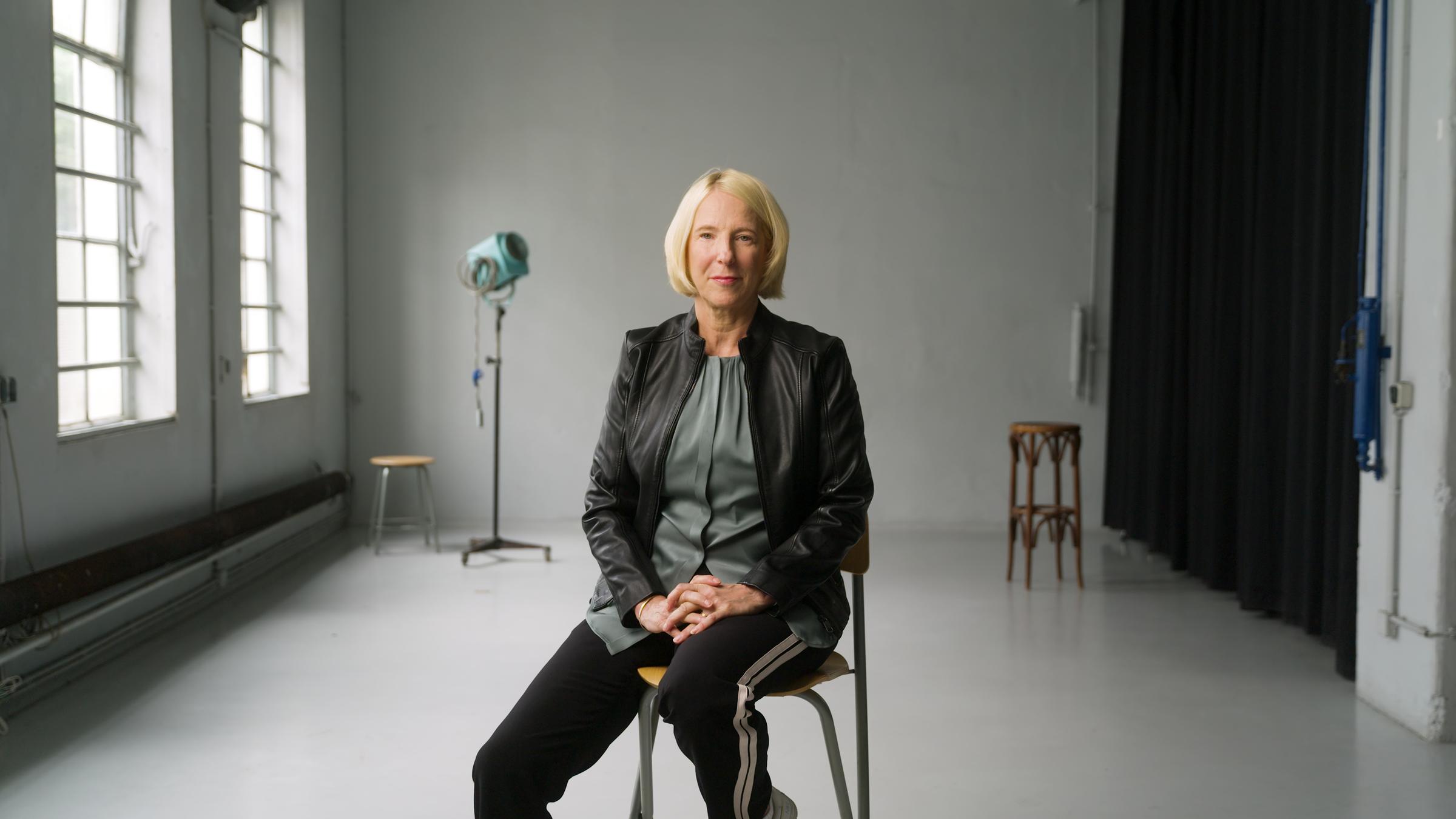 "ZDFzoom: An allen Fronten - Wie Kriegsreporter*innen arbeiten": Katrin Eigendorf sitzt in einem Fotostudio auf einem Stuhl.