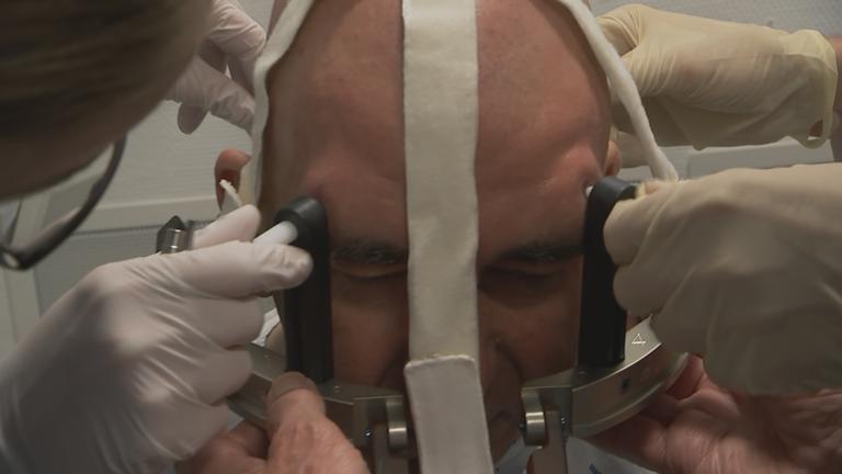 "Neue Therapien gegen Parkinson": Nahaufnahme: Am Kopf eines Mannes wird eine Apparatur zur Ultraschall-Untersuchung angebracht.