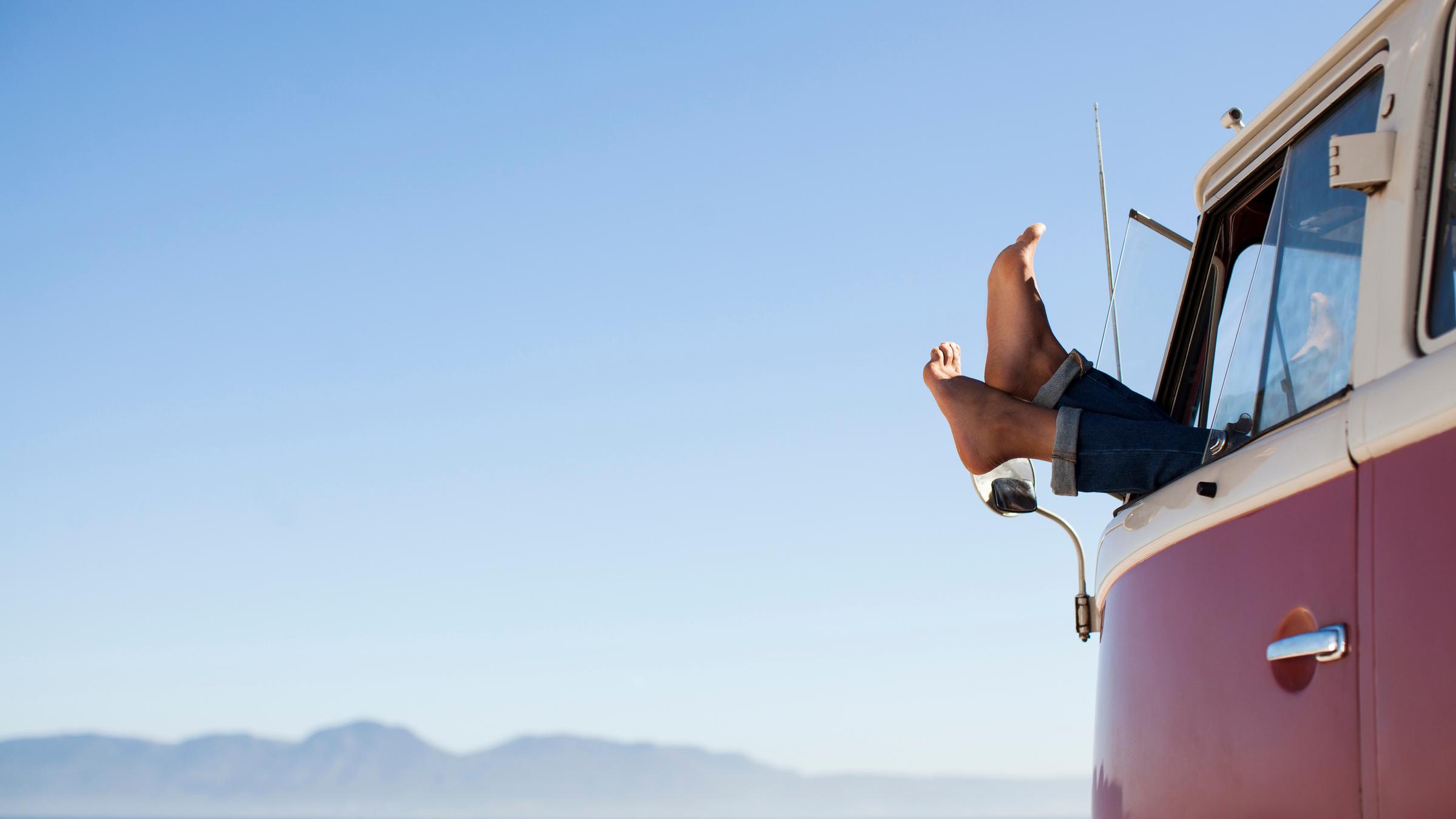 "ZDFzeit: Früher war alles besser! Oder? - Frei Fahrt und freie Meinung": Vor einem idyllischen Meereshintergrund steht ein alter, roter VW Bulli, aus dessen Fenster ein paar nackte Füße baumeln.
