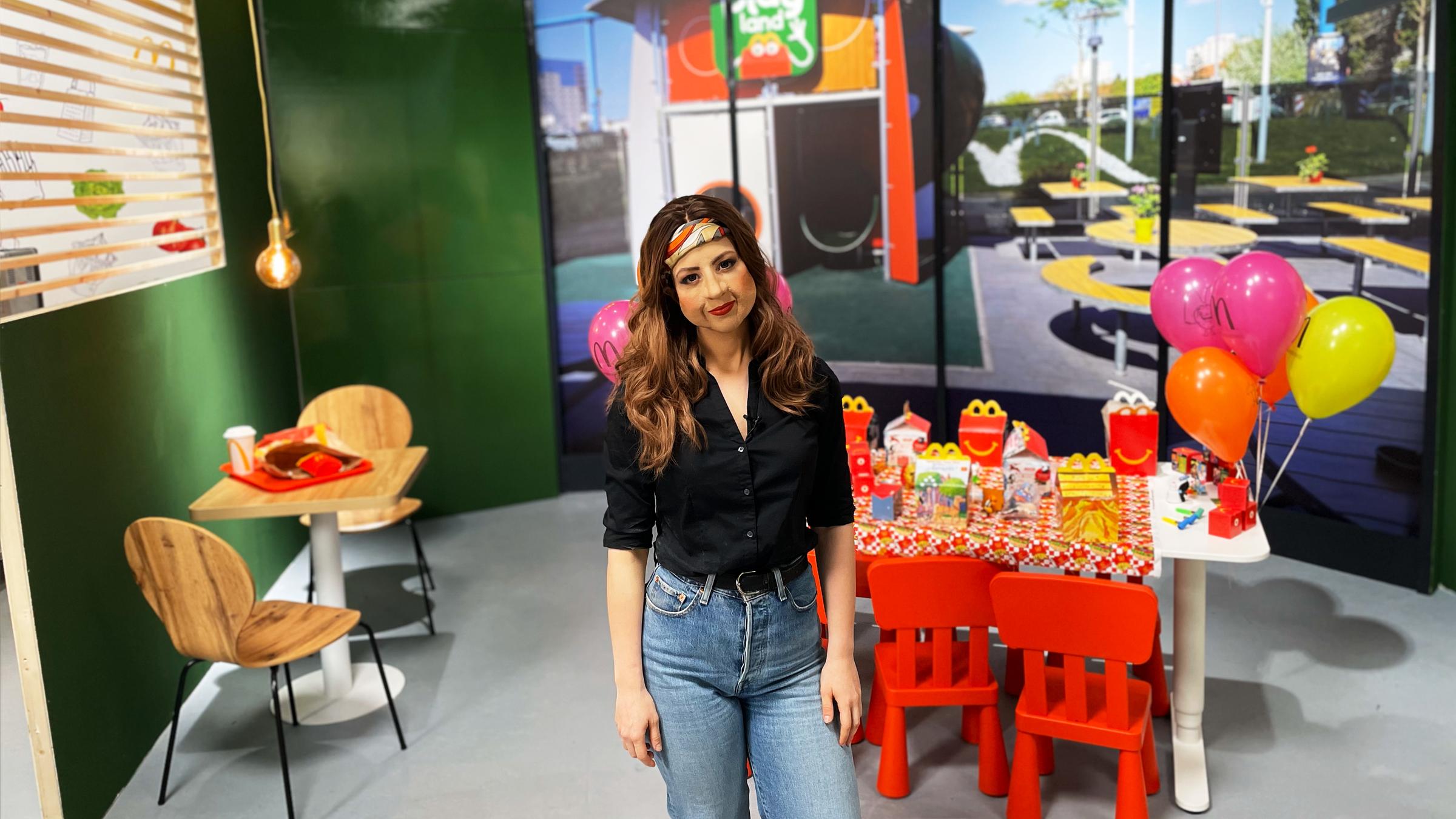 "ZDFzeit: McDonald´s: Die Insider - Die Tricks des Fast-Food-Riesen": Eine anonymisierte Insiderin steht in einer nachgebauten McDonald's-Filiale, hinter ihr ein bunt geschmückter Kindertisch mit Luftballons und "Happy Meals".